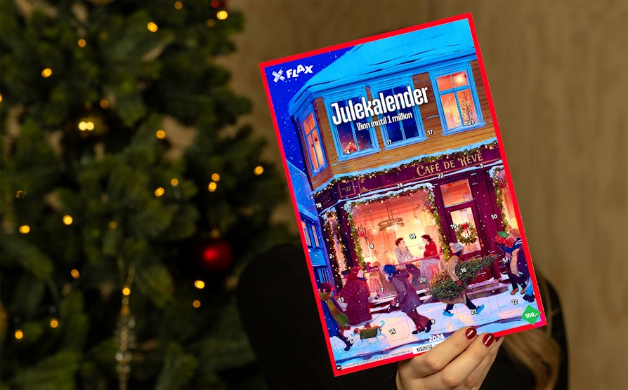 Person holder Flax Julekalender. Juletre i bakgrunnen