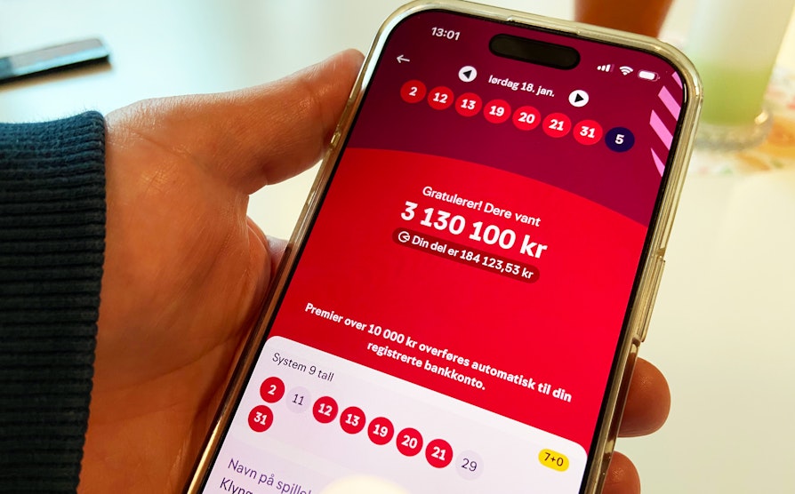 Nærbilde av mobiltelefon med vinnerbeskjed fra Lotto.