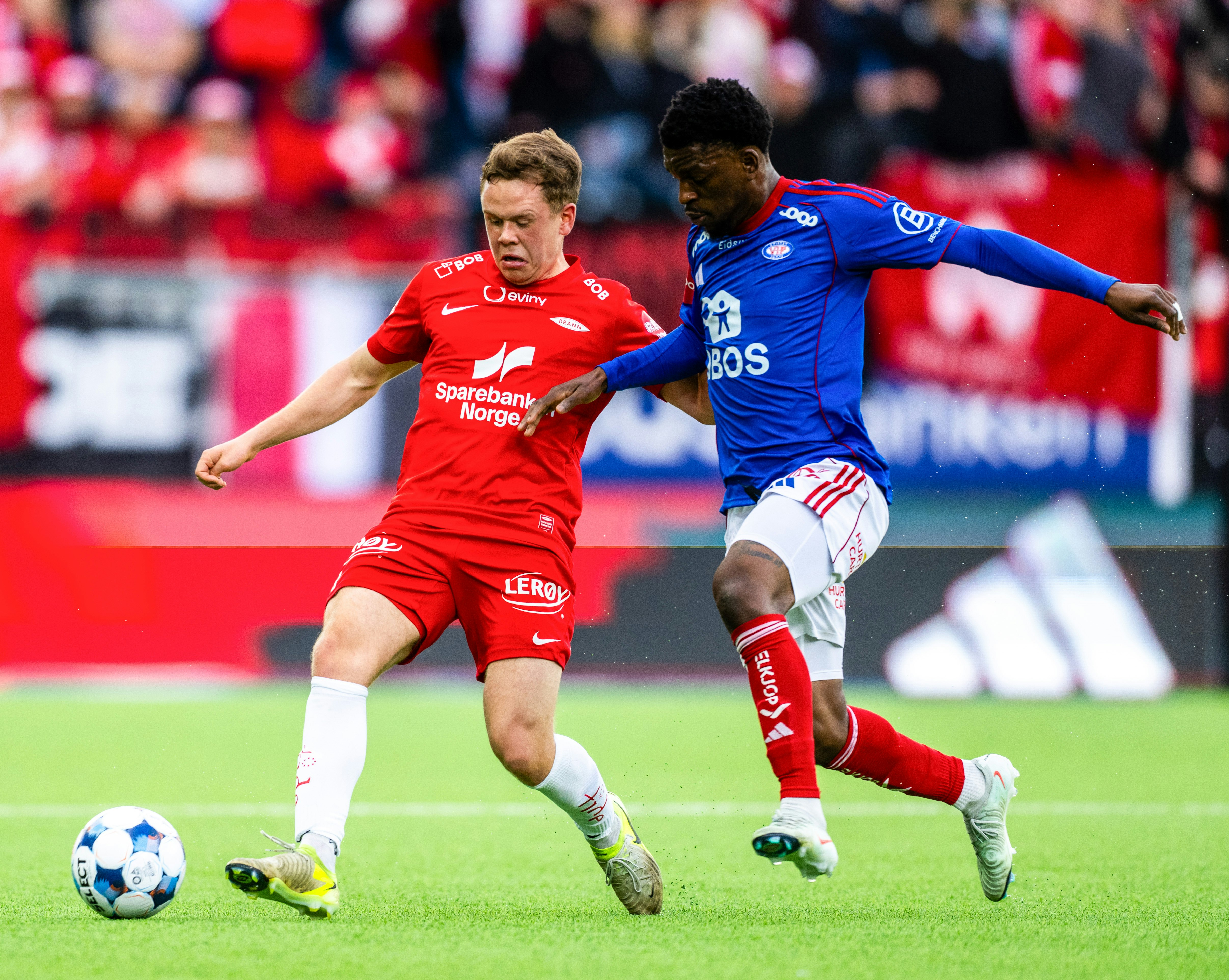 Branns Eggert Aron Gudmundsson i duell med Vålerengas Brice Ambina under eliteseriekampen i fotball mellom Vålerenga og Brann på Intility arena.