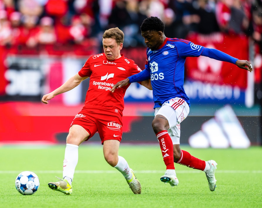 Branns Eggert Aron Gudmundsson i duell med Vålerengas Brice Ambina under eliteseriekampen i fotball mellom Vålerenga og Brann på Intility arena.