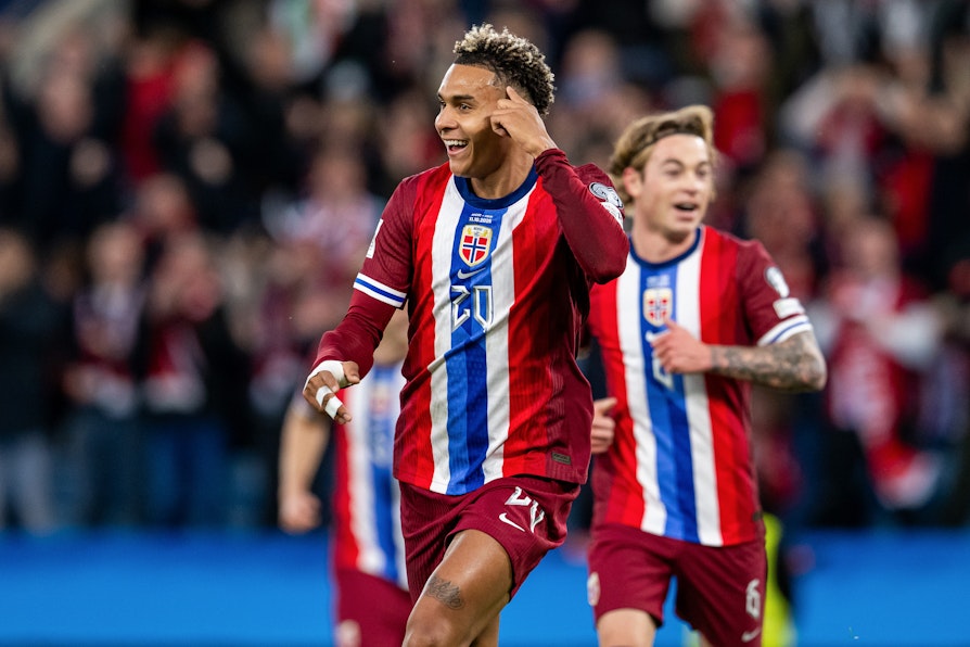 Landslagsspiller Antonio Nusa smiler og løper. Patrick Berg løper i bakgrunnen.