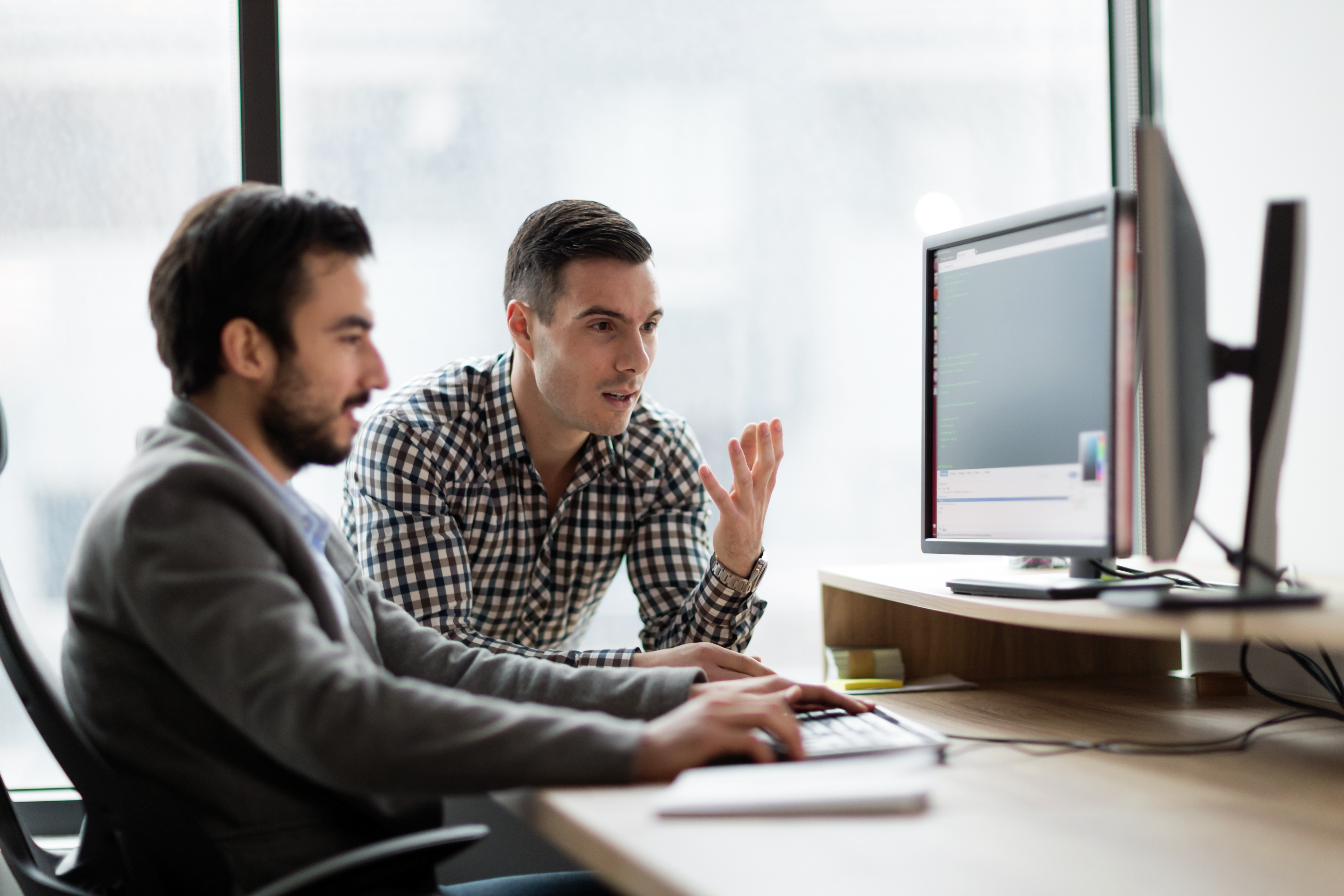 Jonge ondernemers die op kantoor aan de computer werken