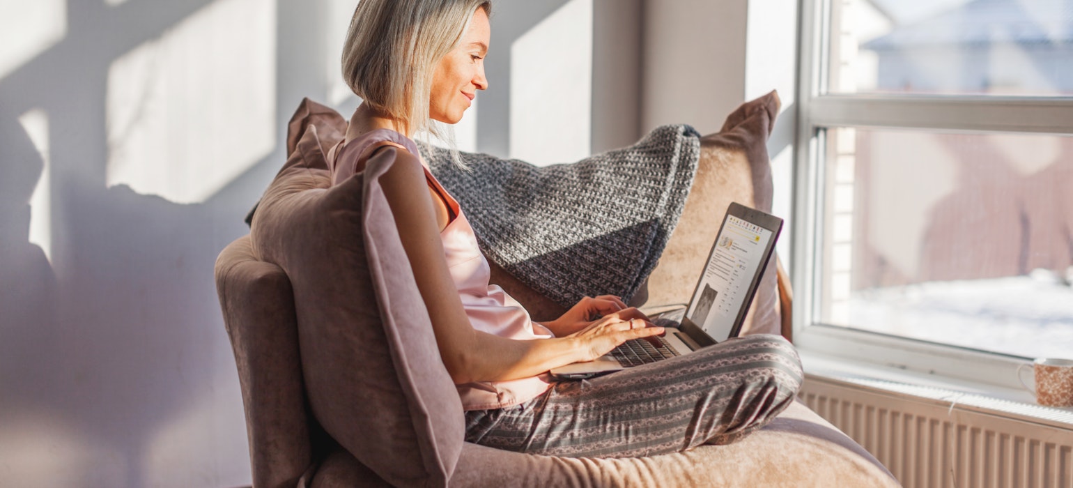 femme en pénis assise sur un canapé dans le salon avec une tasse de thé ou de café