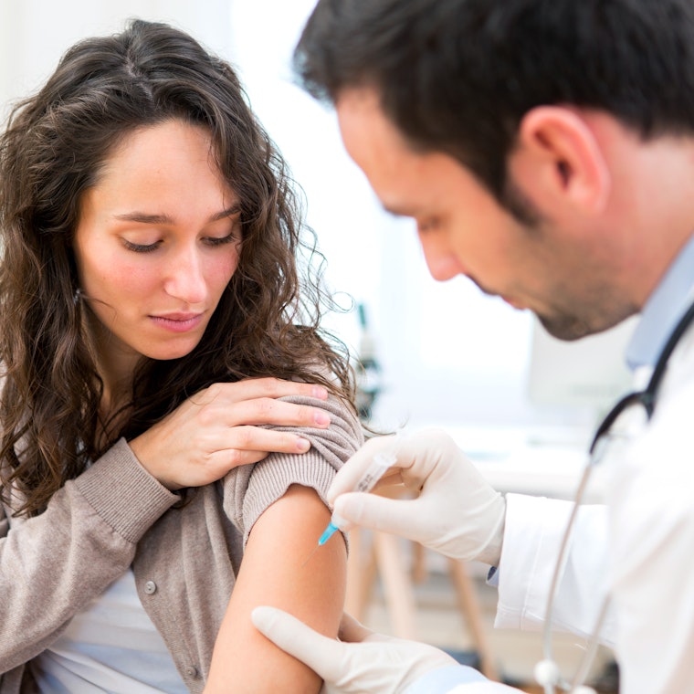 Jonge vrouw wordt gevaccineerd.