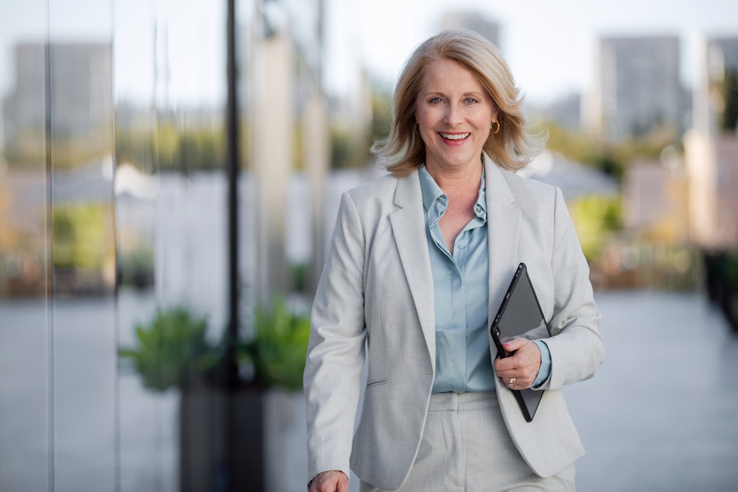 Vrouwelijke CEO loopt naar gebouw in financieel district
