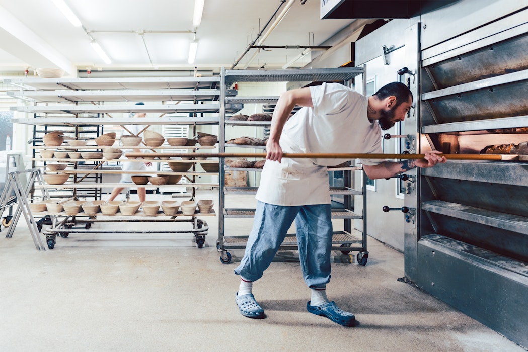 Bakker controleert brood in de bakkersoven