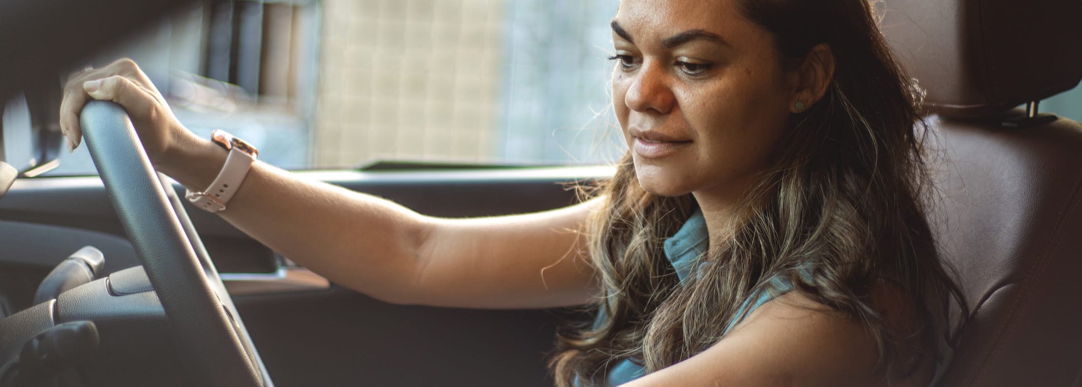 woman reading over to her radio in a car