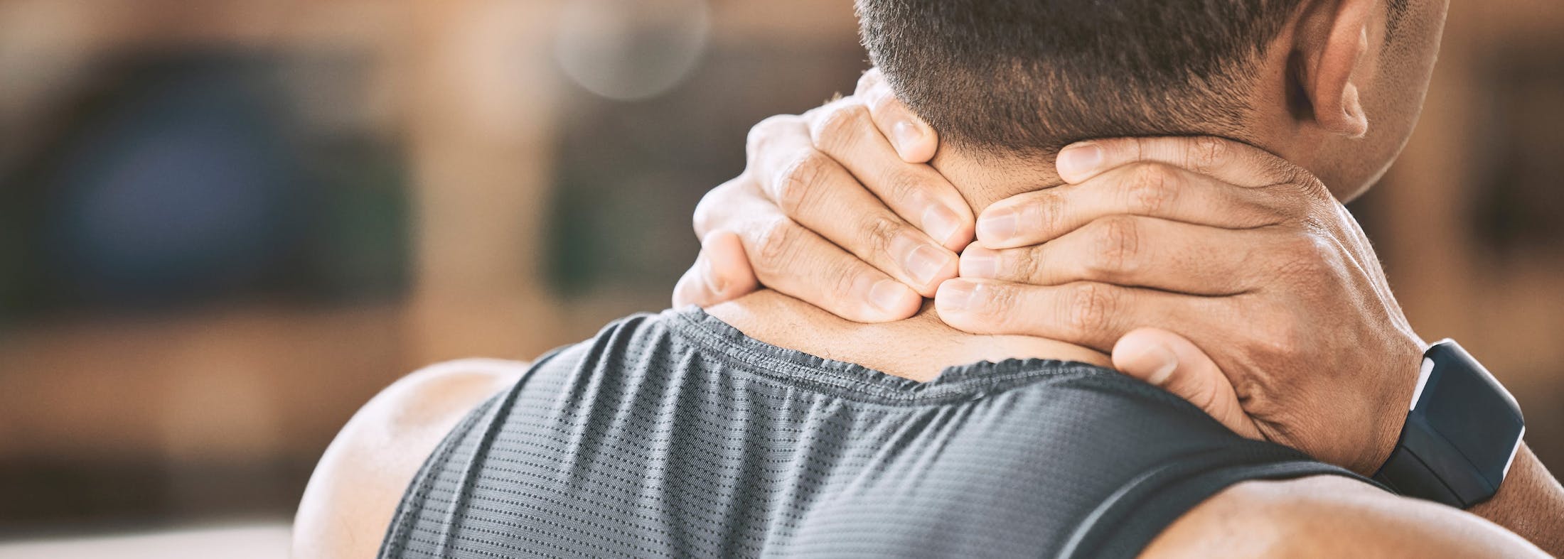 Man massaging his neck with his hands