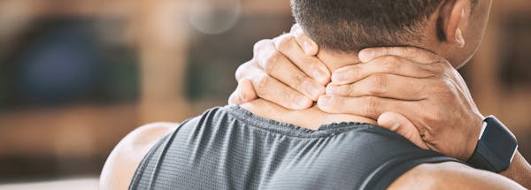 Man massaging his neck with his hands