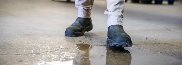 Person stepping into a puddle of water