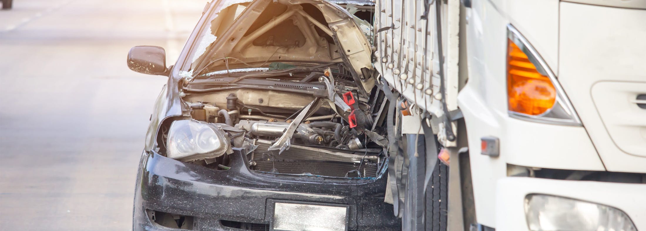 Crashed car underneath a semi truck