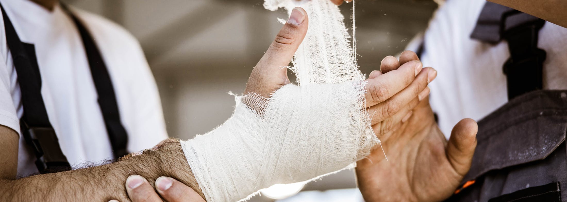 Person getting their hand wrapped in gauze