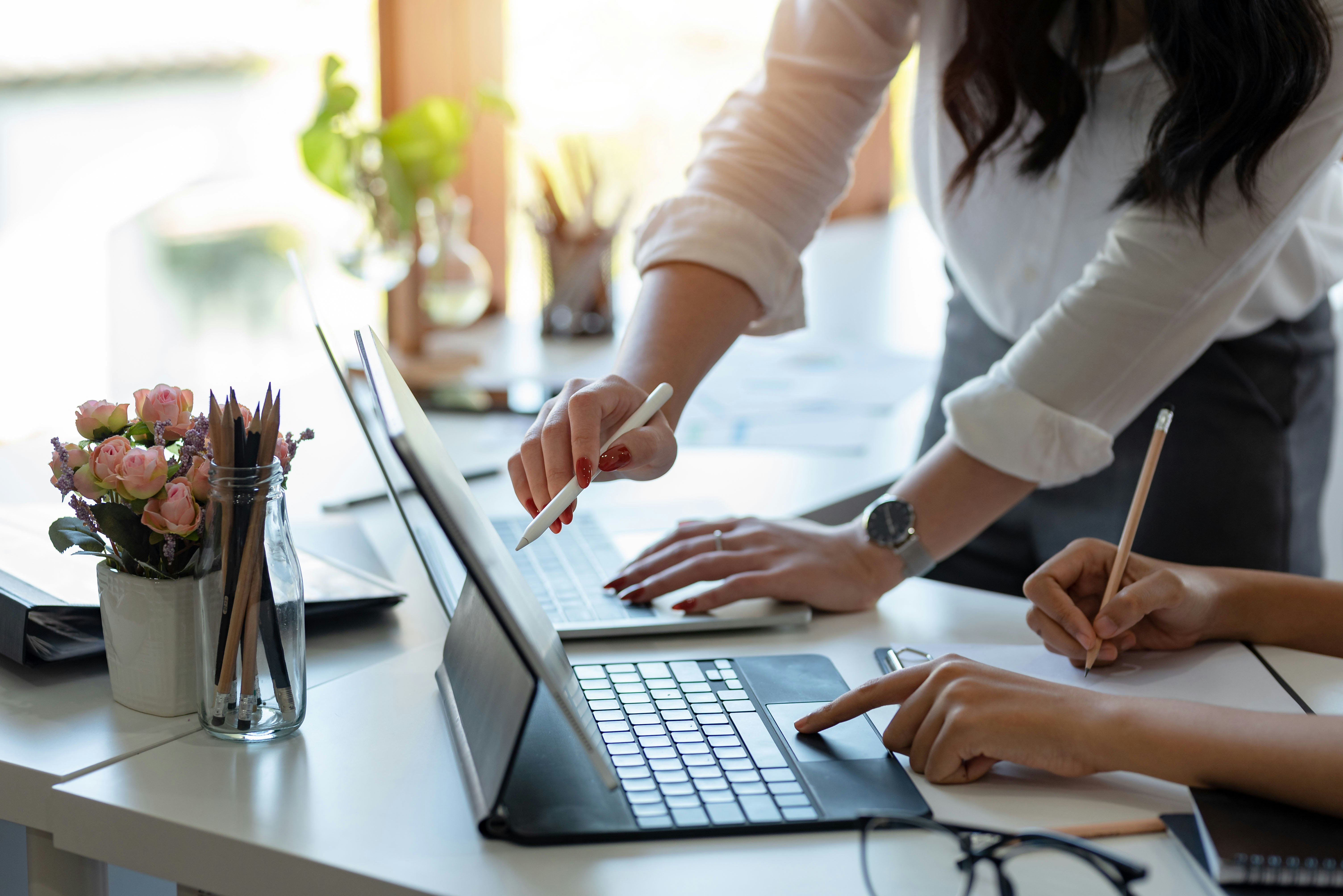 Woman pointing to something on another woman's screen at work.