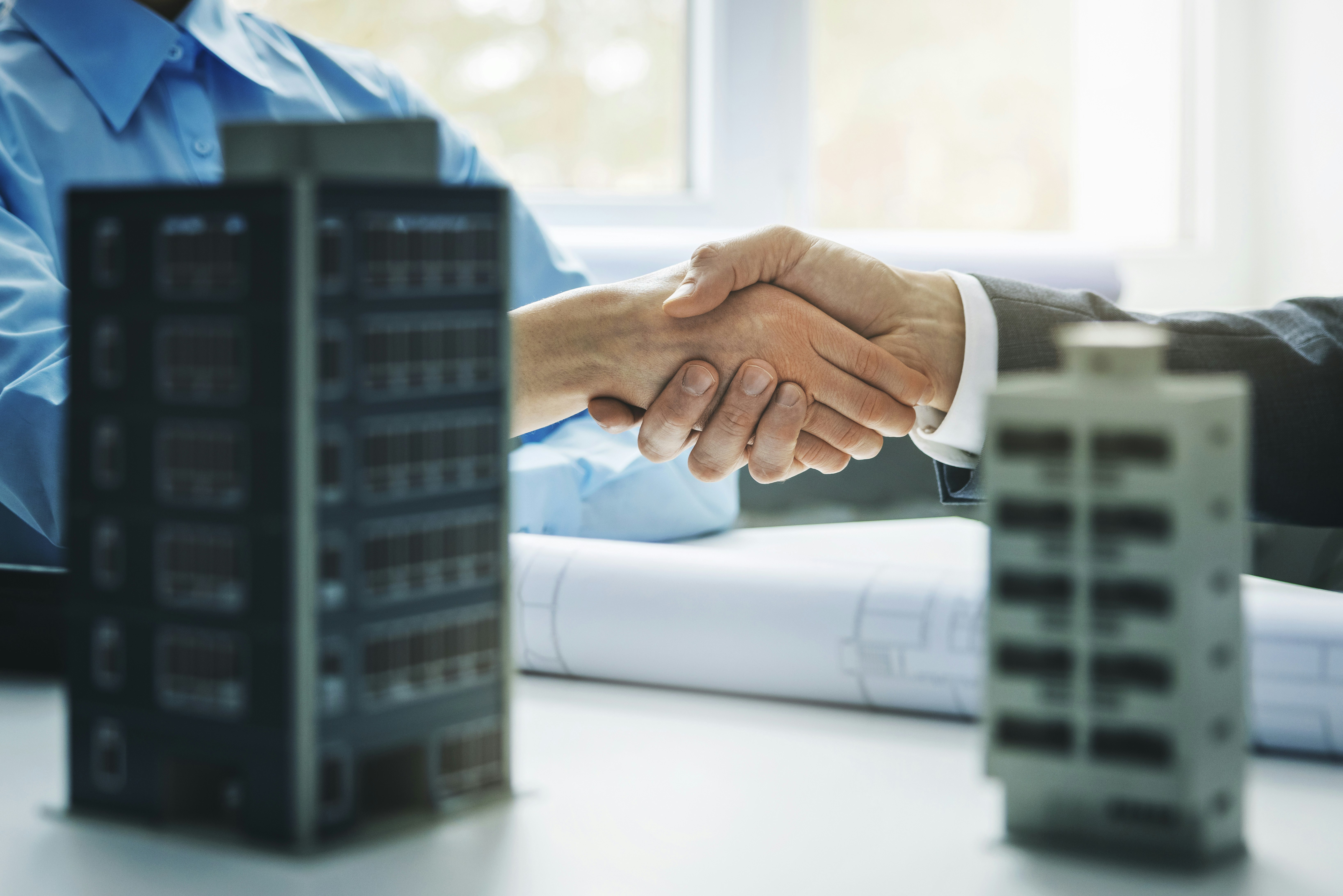 Woman and man shaking hands over real estate deal.