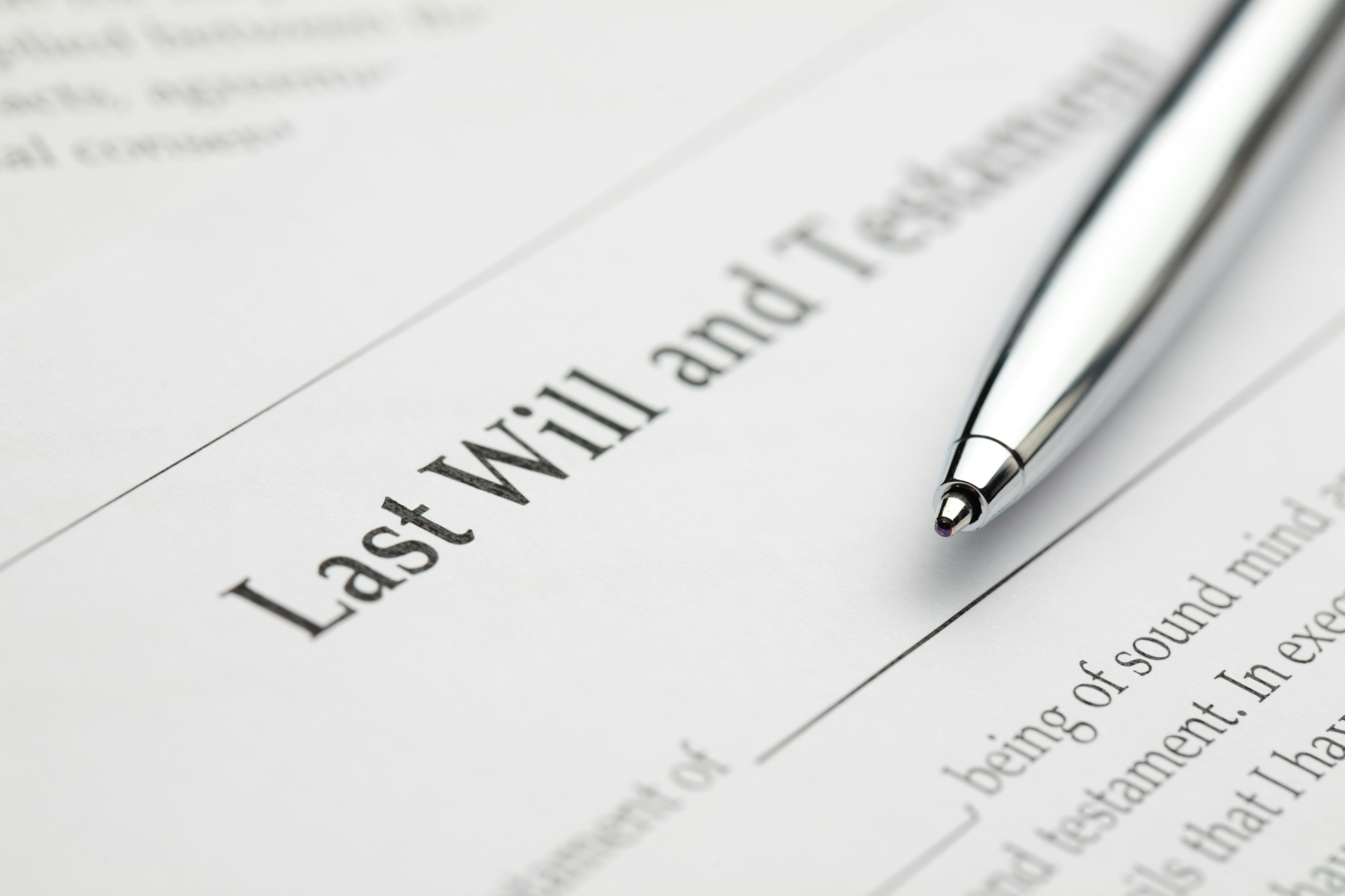 Last will and testament with pen laying on paper.