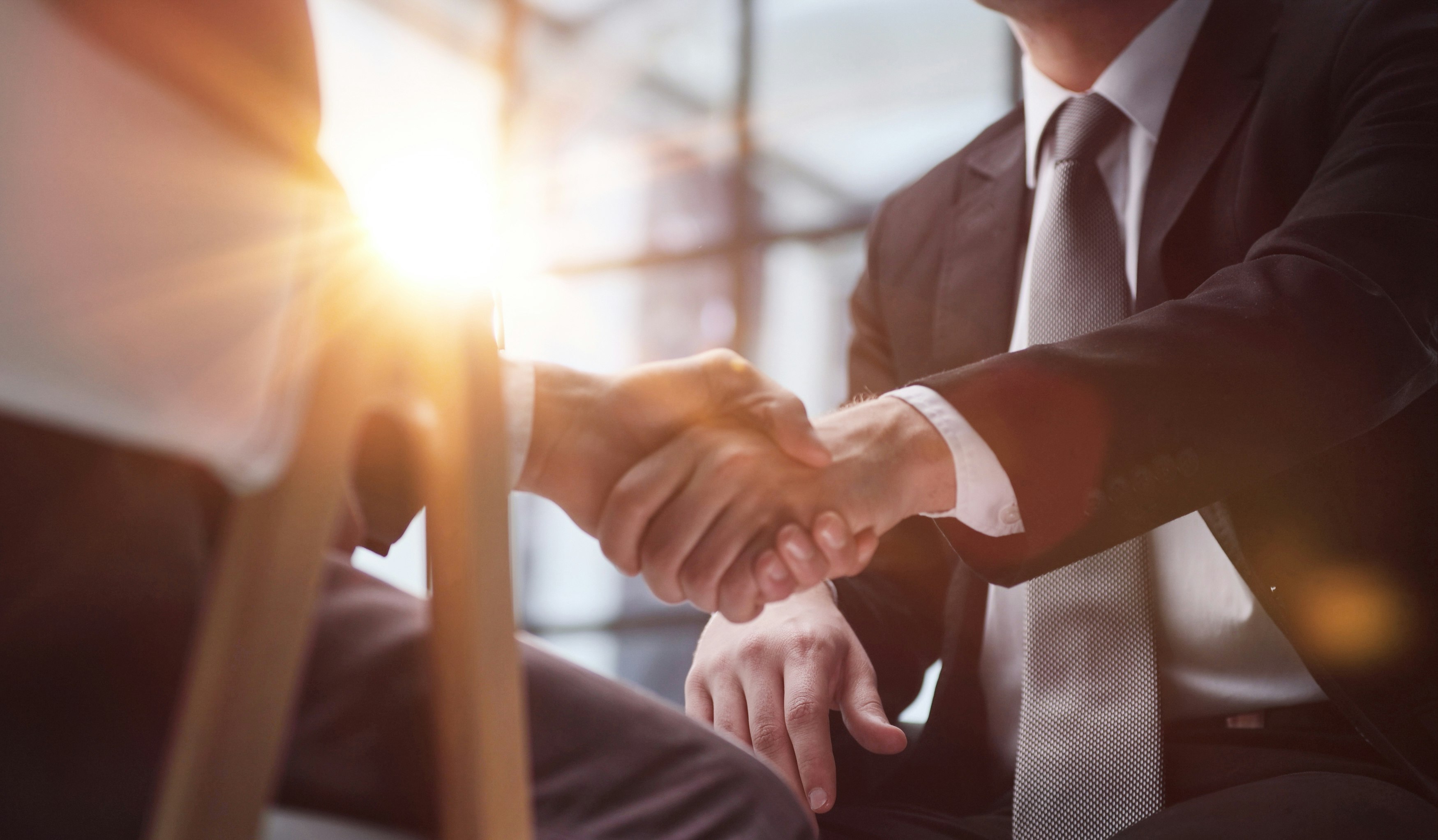 Two advisors shake hands.