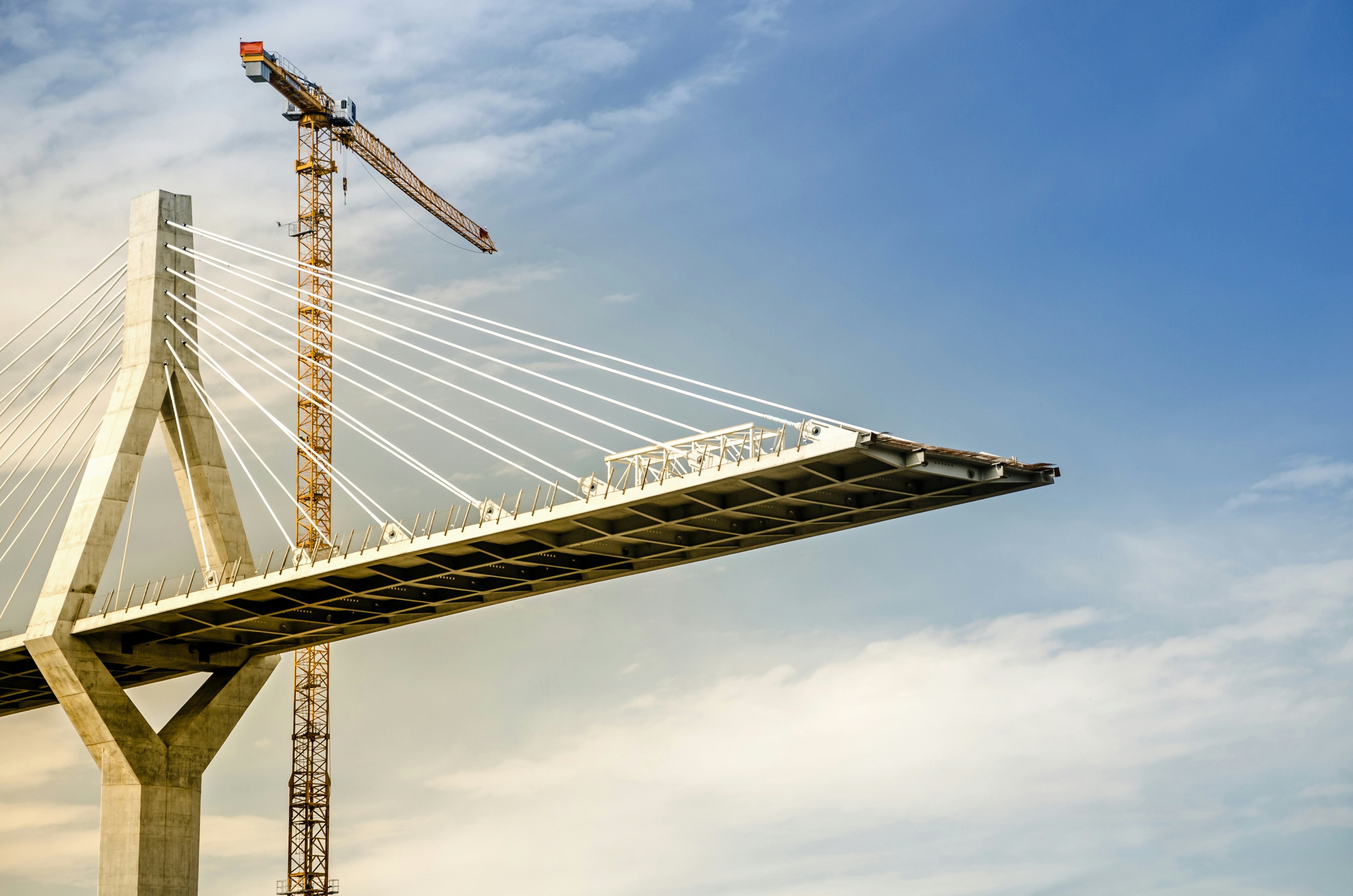 Infrastructure in a declining rate environment A bridge in the construction process with a crane in the back.
