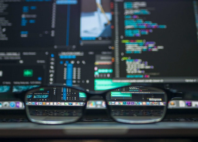 Glasses in front of code screen