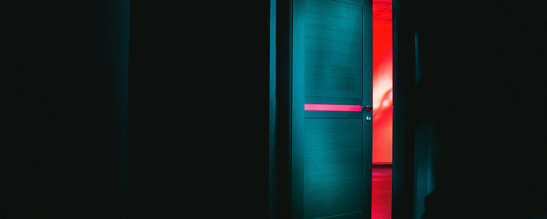 A locked door with a shadowy figure inside
