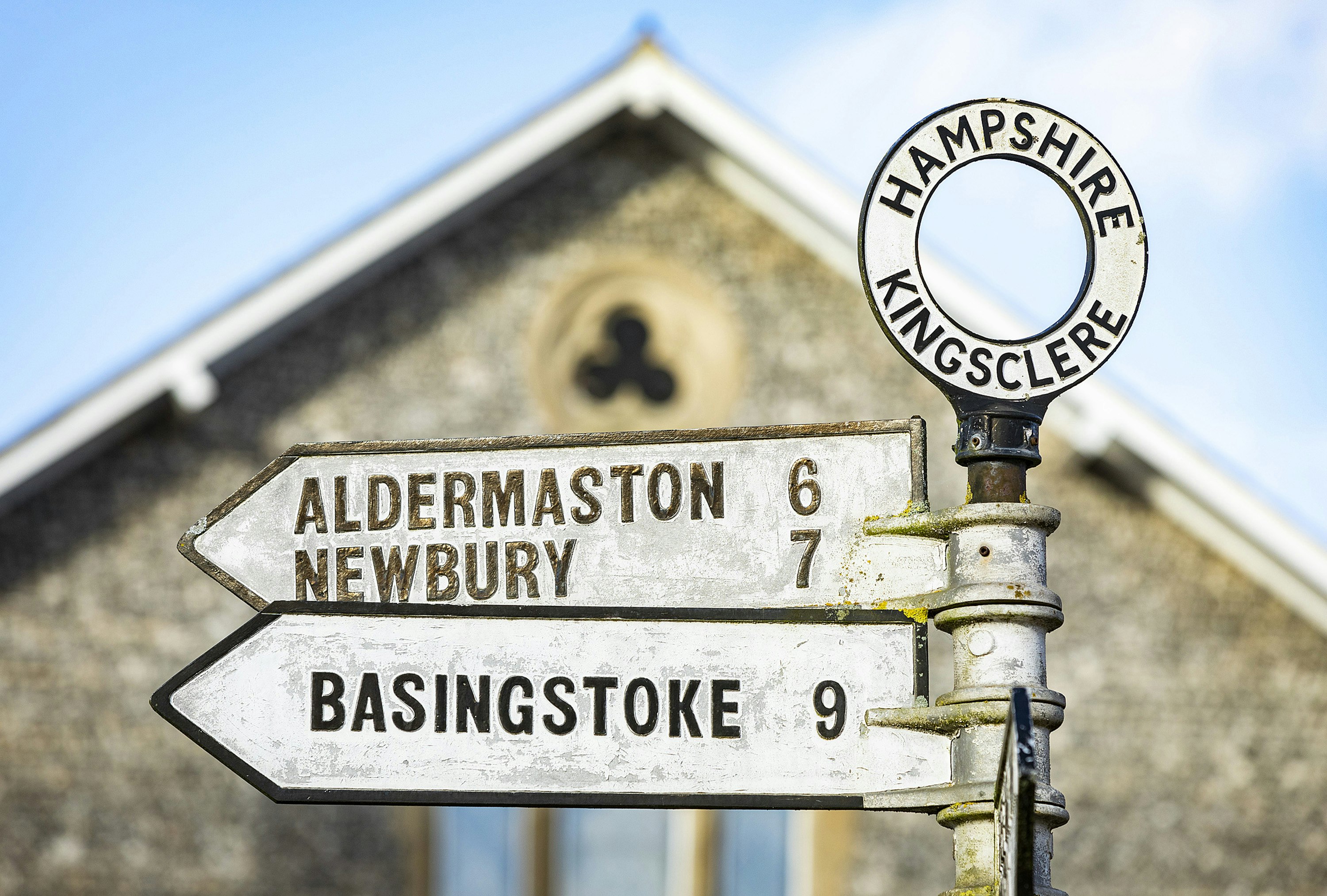 A road sign with a circle at the top showing Hampshire, Kingsclere. Directional signs show Aldermaston 6, Newbury 7 and Basingstoke 9.