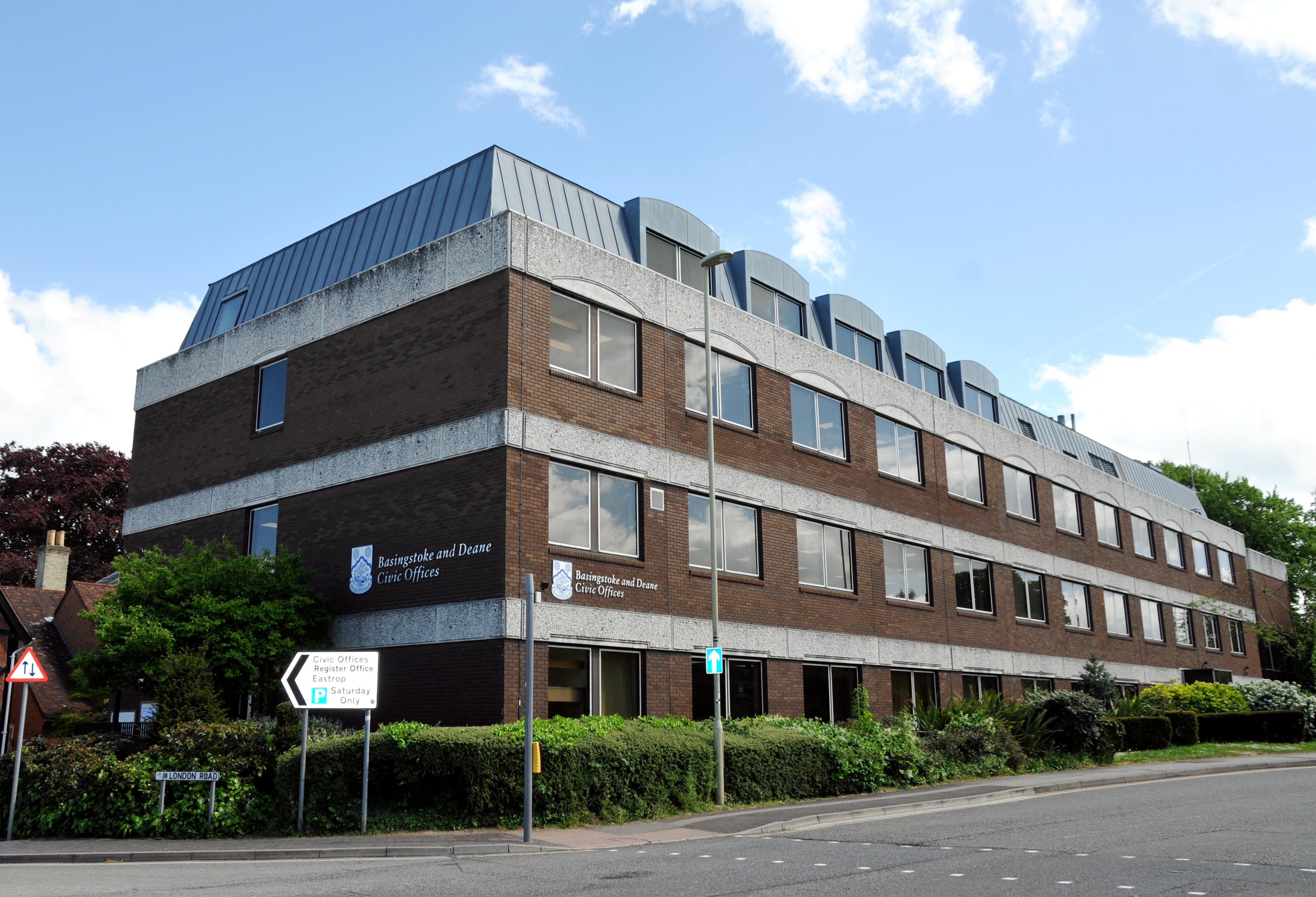 A brown brick 4 storey building on a main road