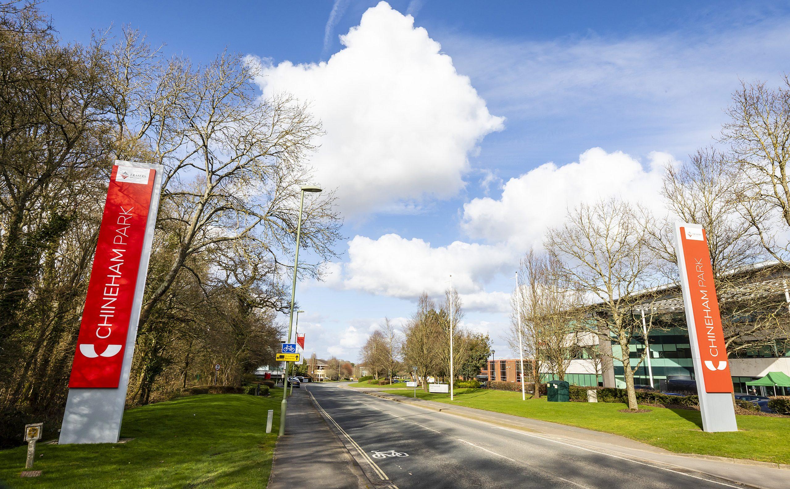 road with red signs saying 'Chineham Park'