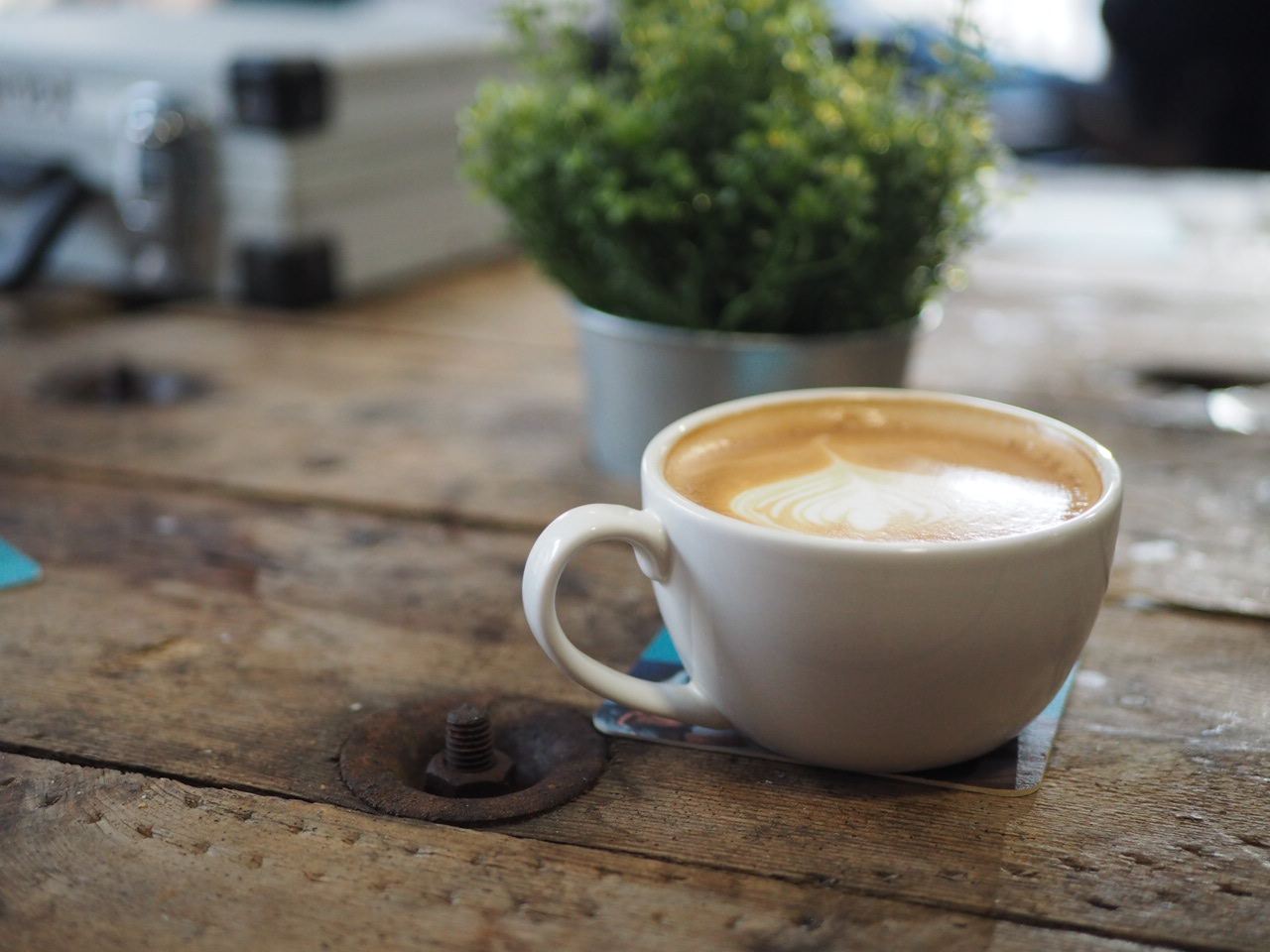 a cup of coffee sits on a wooden table