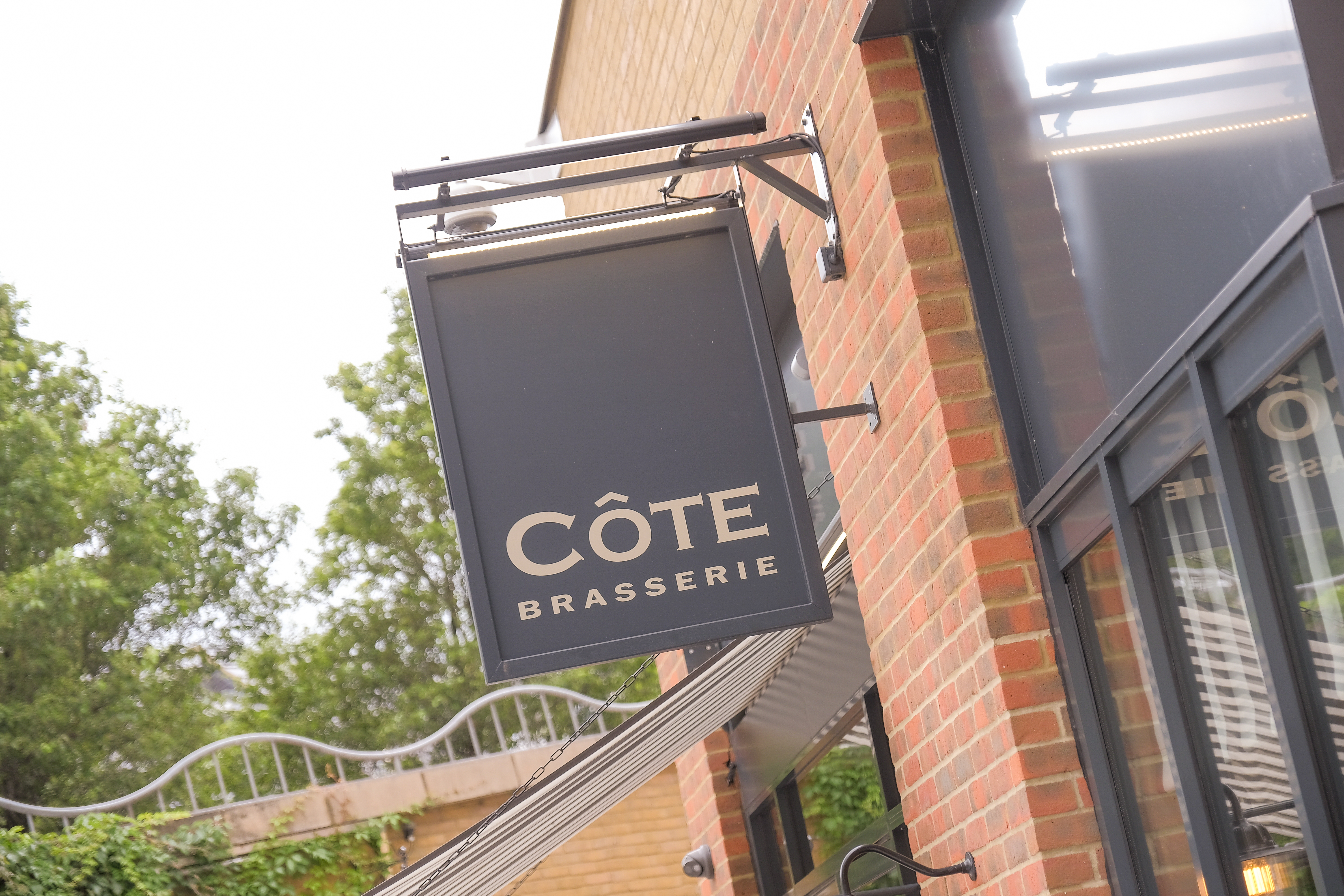 A sign board outside of a restaurant saying Cote Brasserie