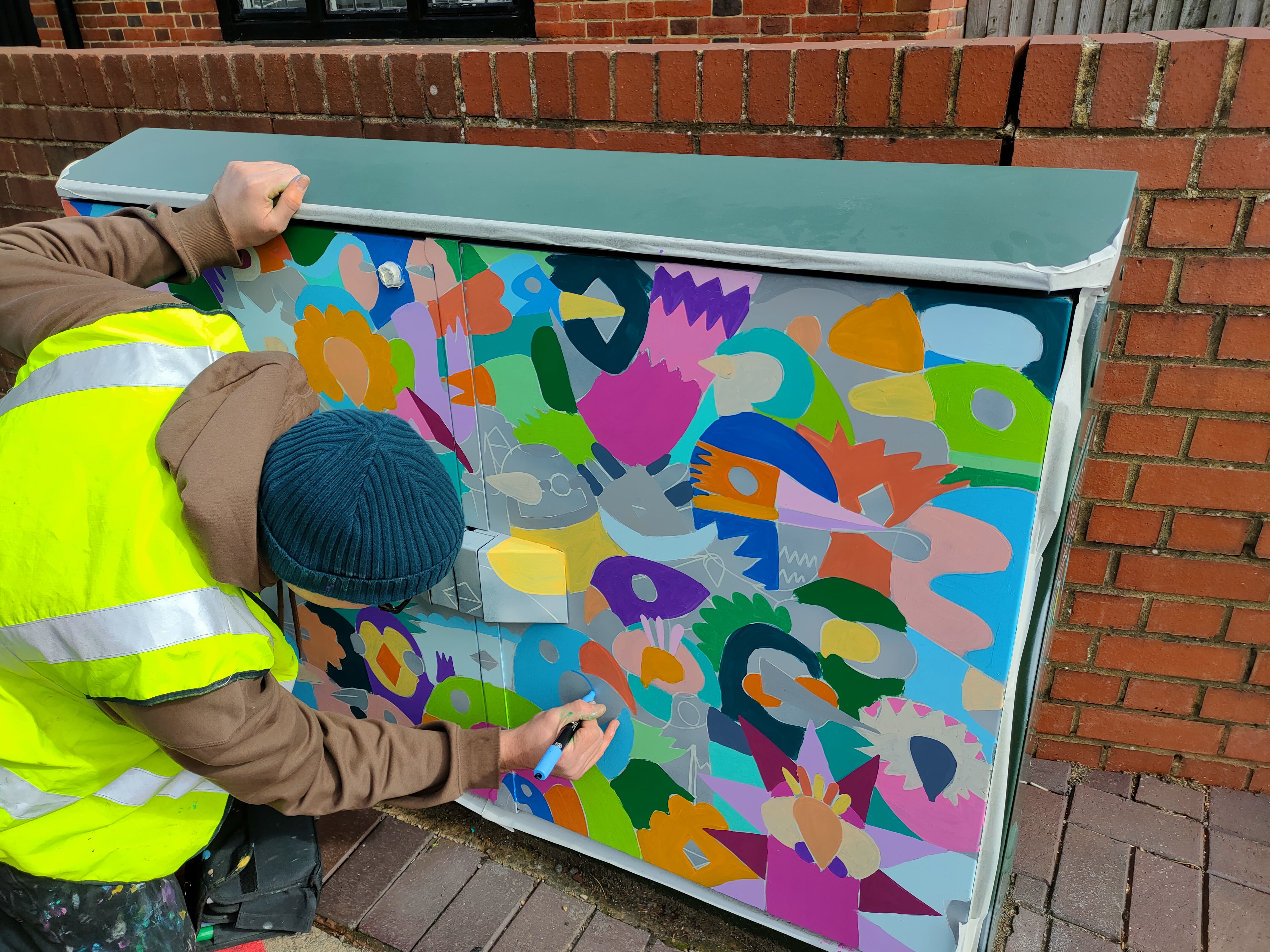 Kev Munday is painting a telecom at New Road