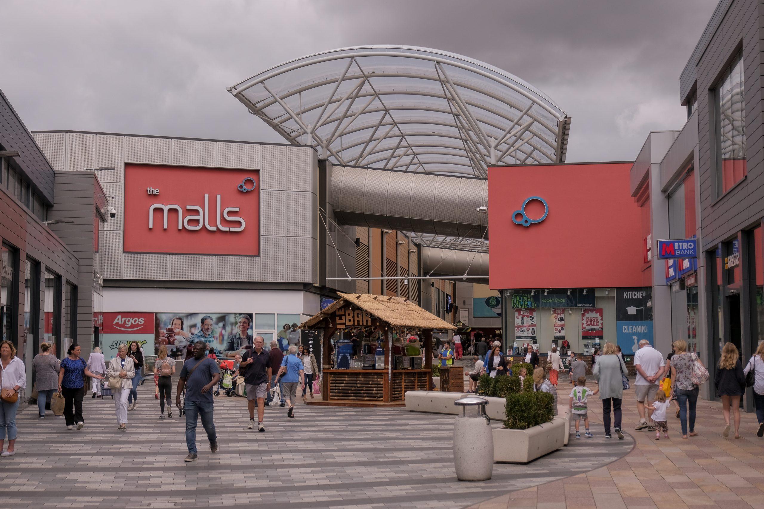 The entrance to the malls. Buildings on either side of a walkway which has a domed glass roof.