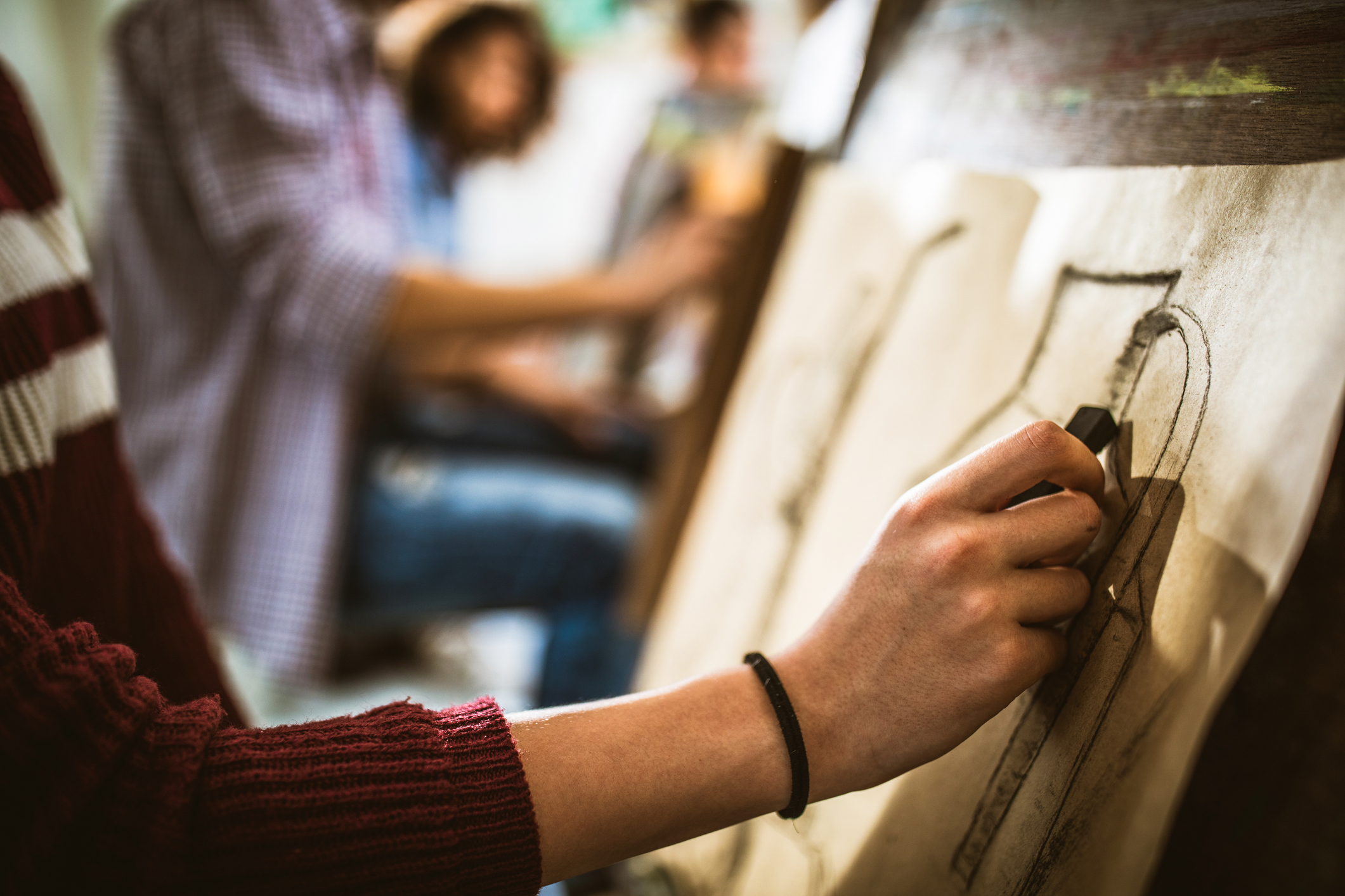 Arts and craft classes, a student drawing on a piece of paper