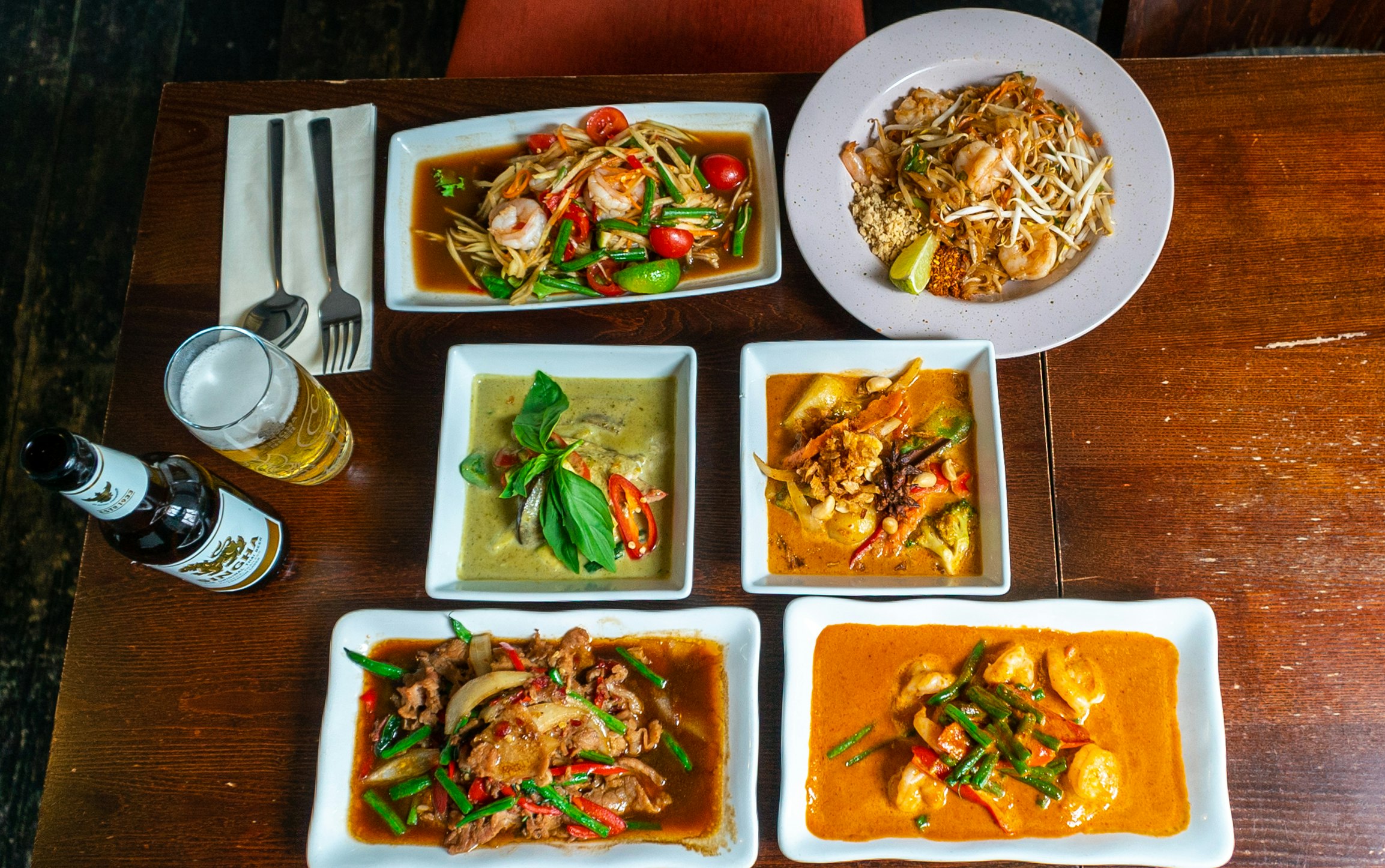 Six dishes of food at the Lime Leaf and a beer.