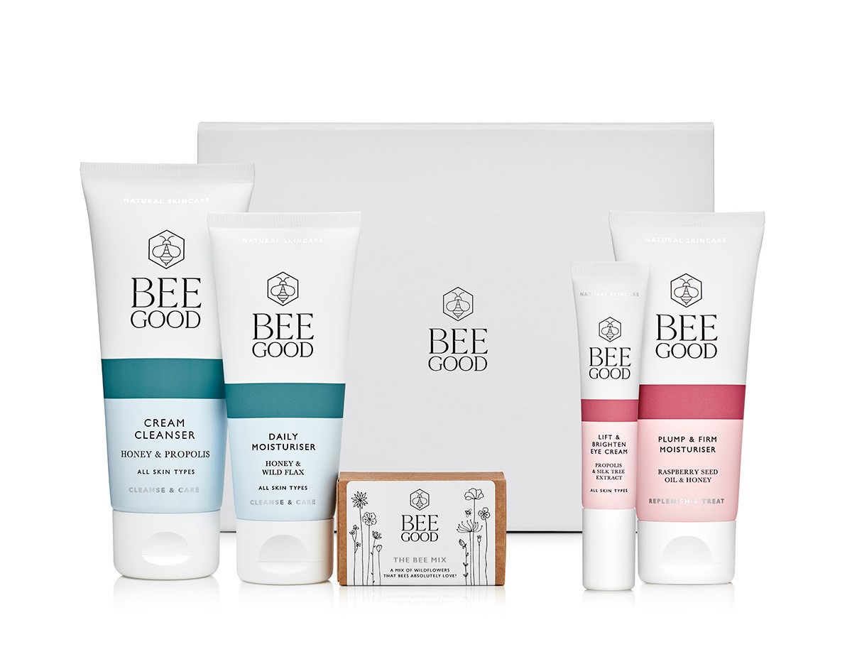 A white box with Bee Good in black writing. Then there are 4 tubes of toiletries and a box.