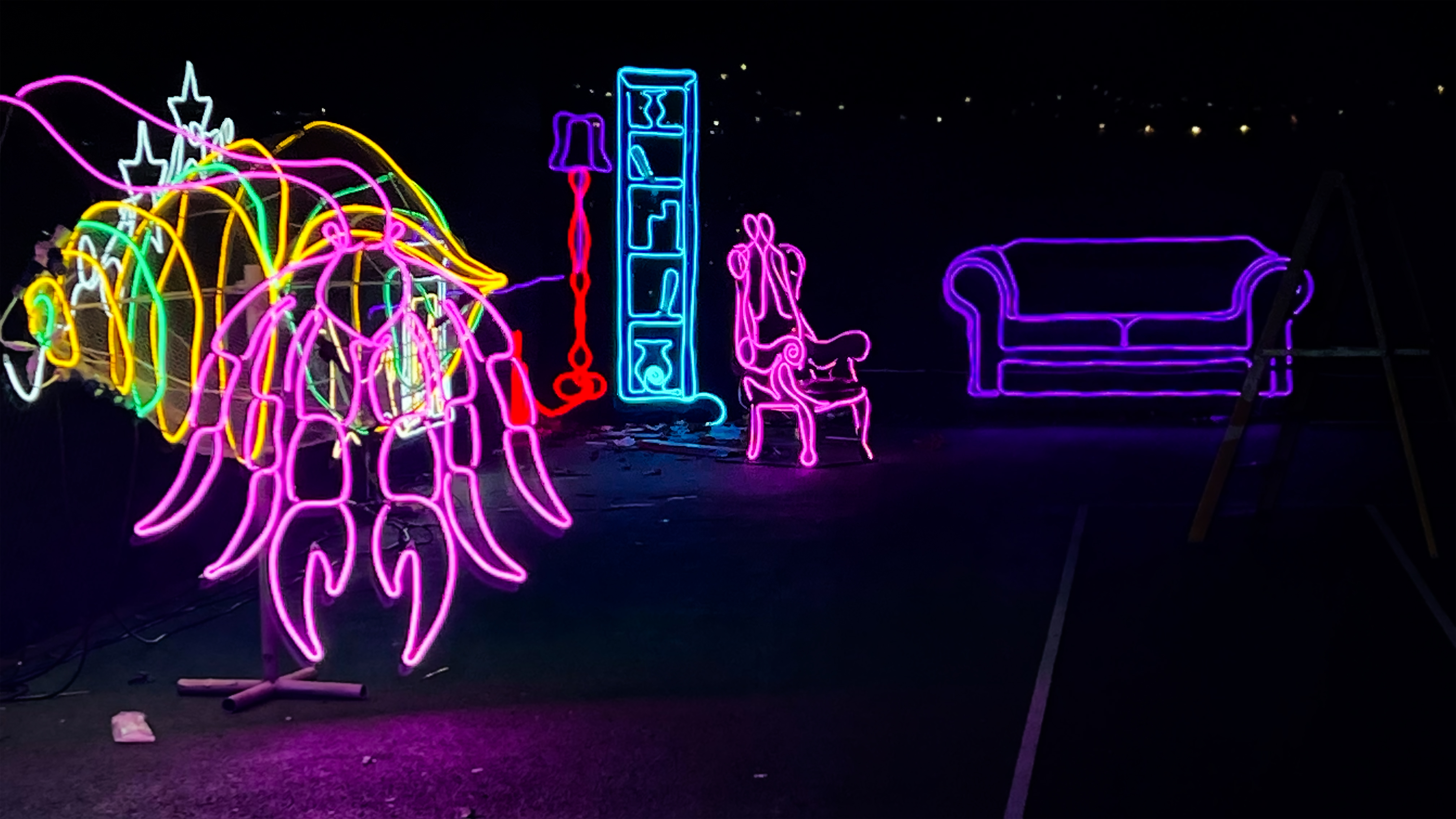 In the dark you can see a number of neon lights. They depict a sofa, armchair and bookcase.