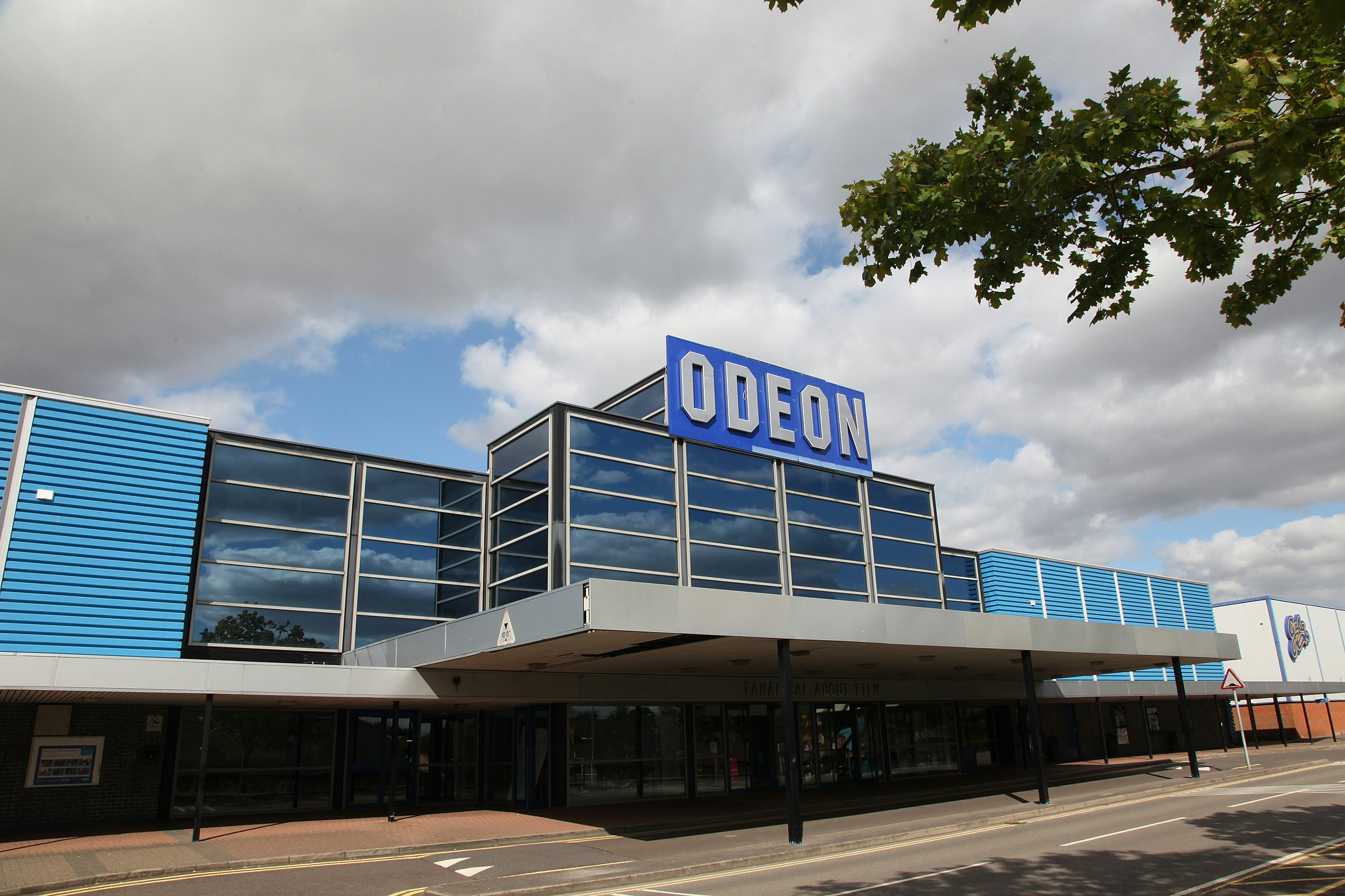 The external of the Odeon. A blue and glass fronted building with a large Odeon Sign over the covered entrance way.