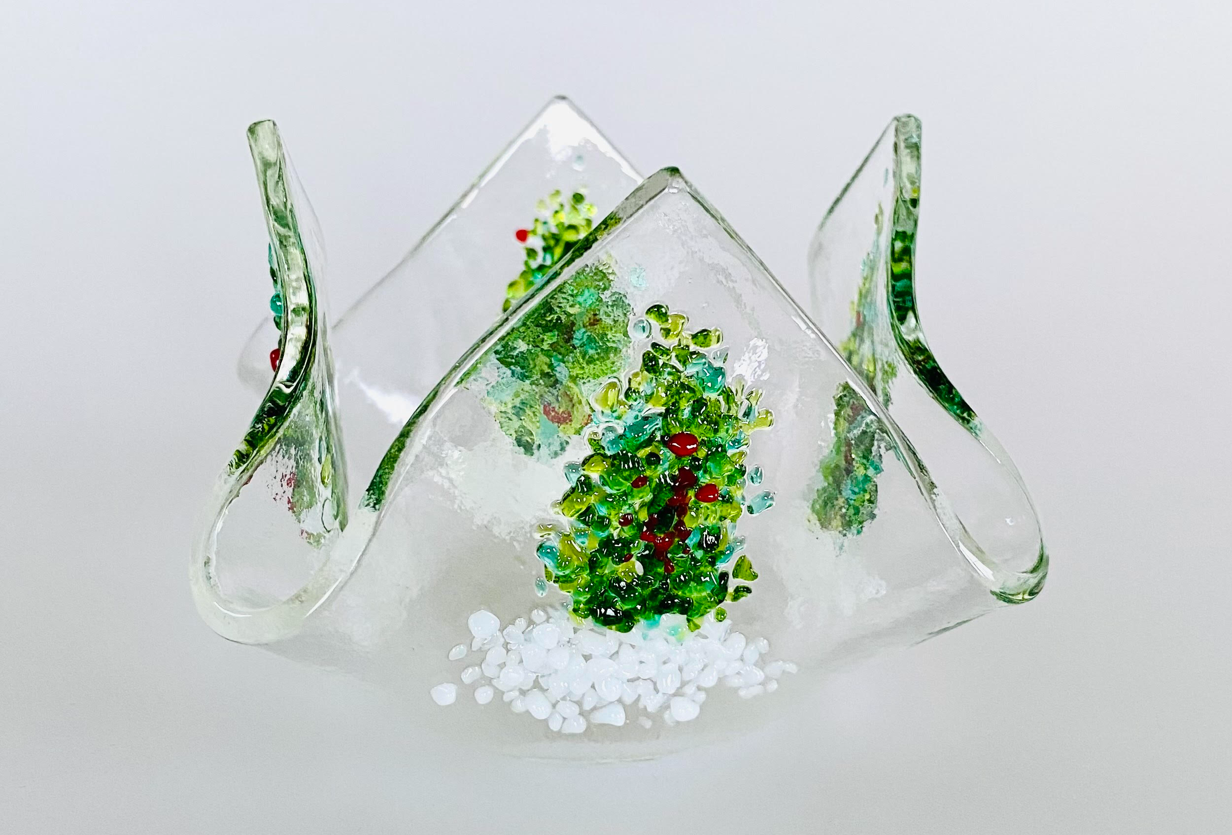 A glass tealight holder which has white and green decoration.