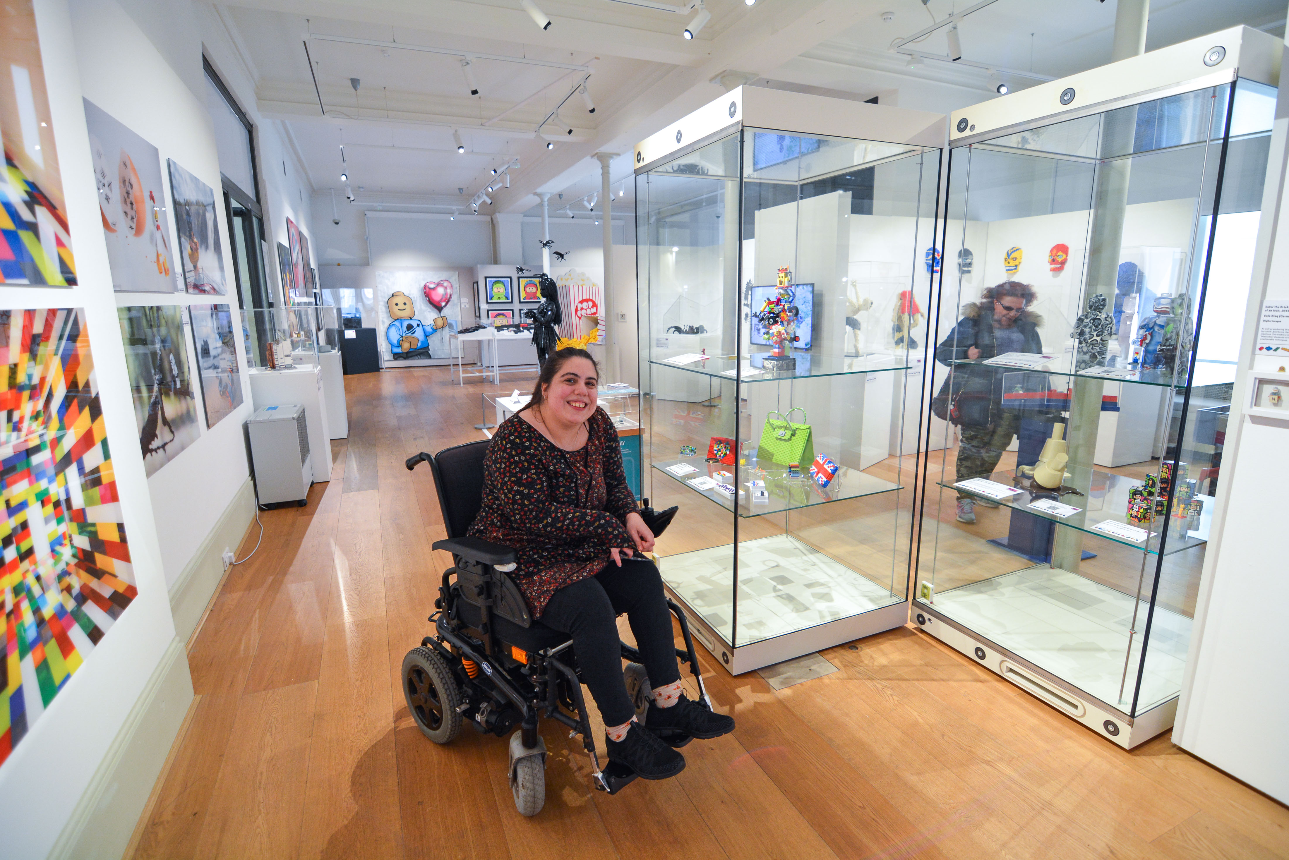 A lady sits in a wheelchair in The Willis Museum.