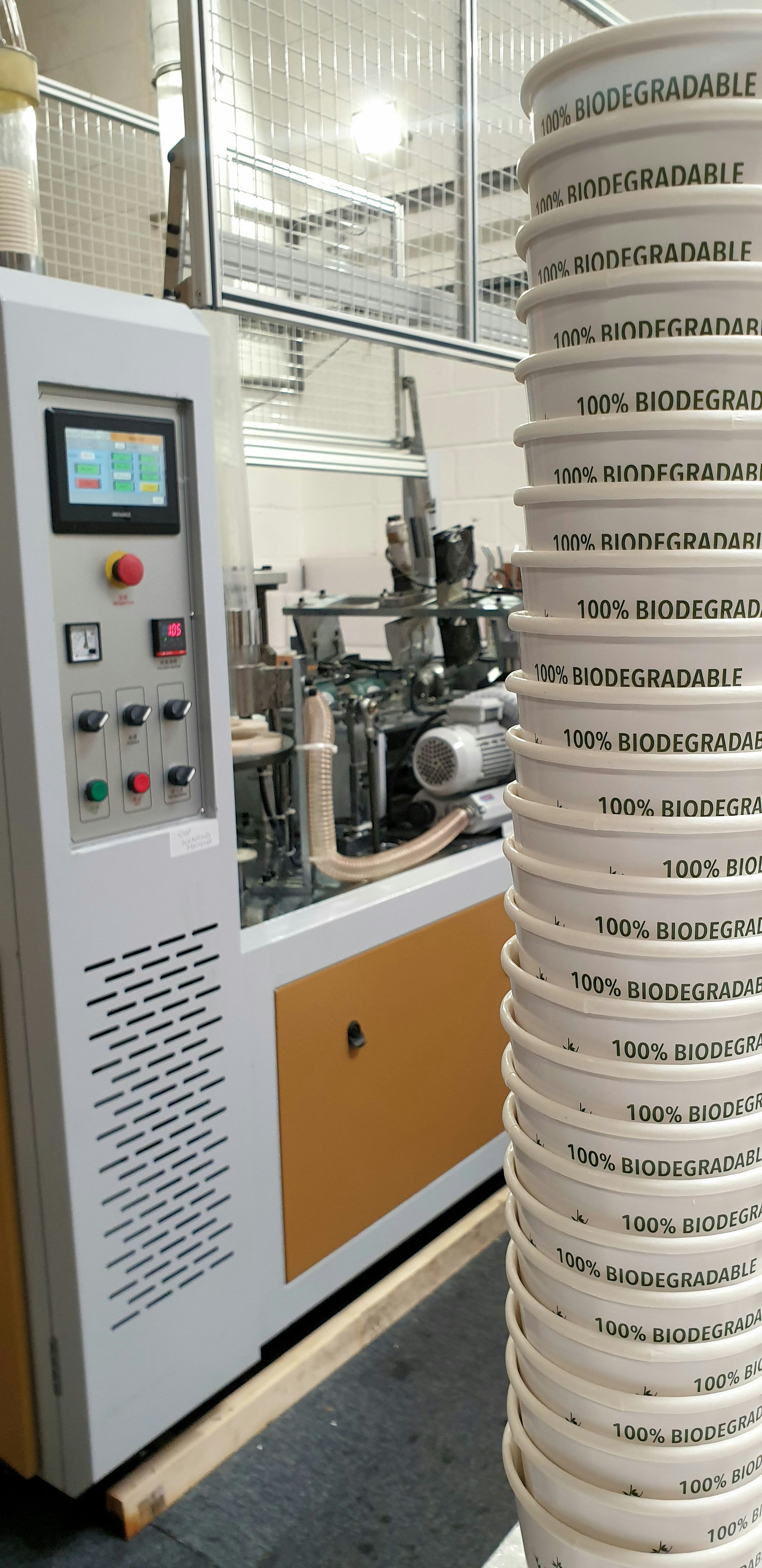 A selection of cups on the right hand side. In the background you can see a machine.