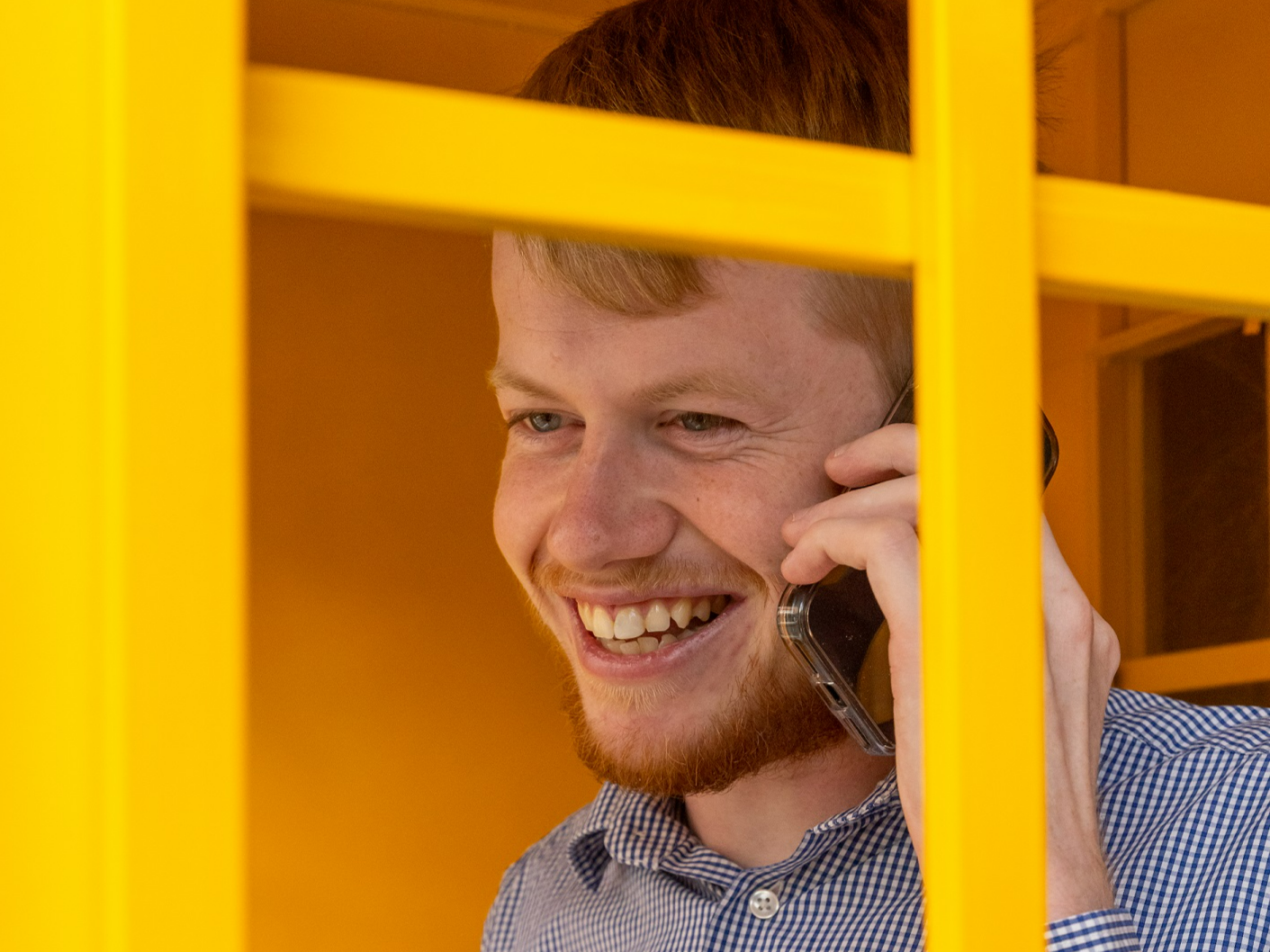 A man holds a mobile phone to his ear and speaks on it.