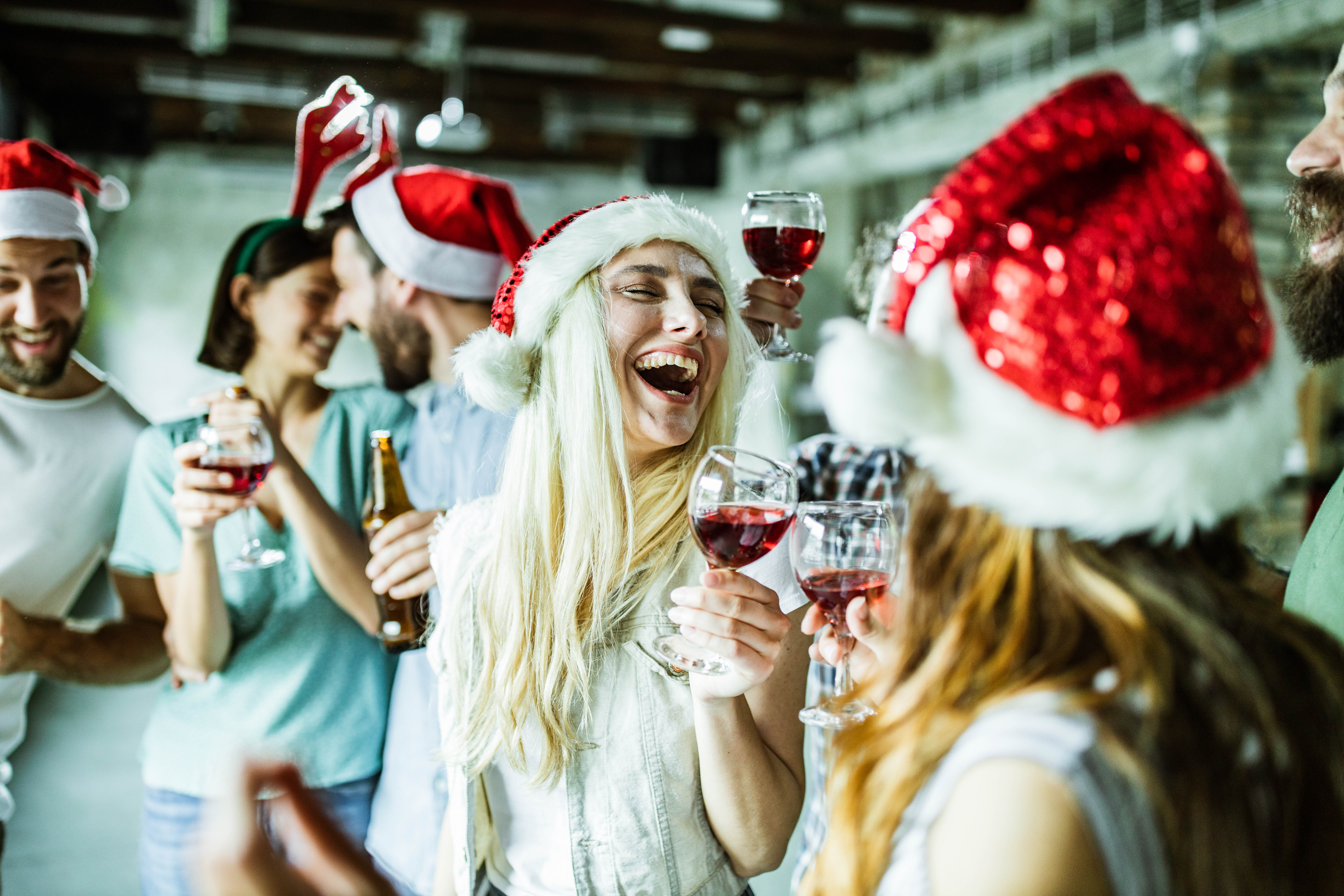 A group of people wearing santa hats and having a good time.