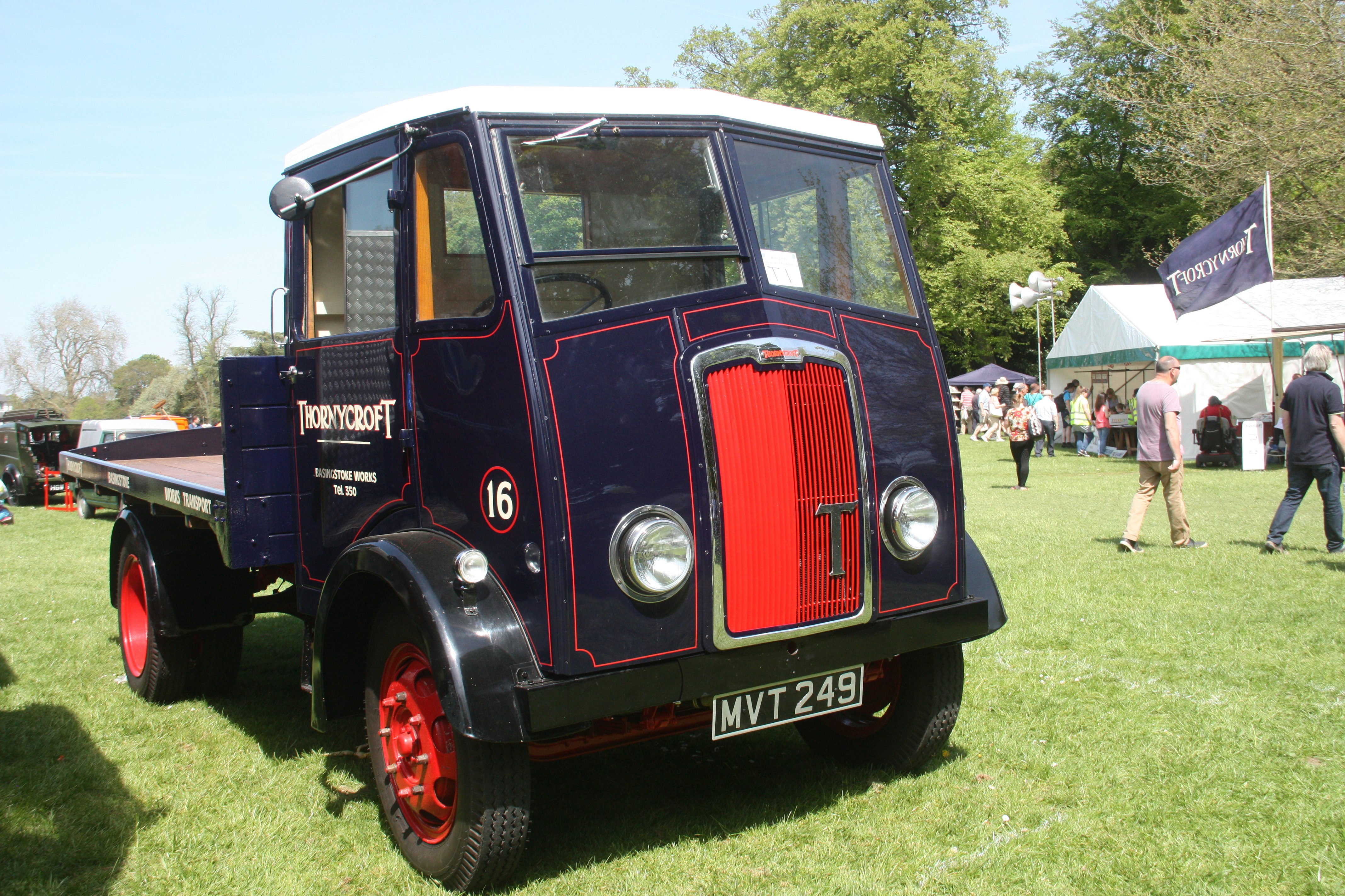 A vintage vehicle is the highlight of the image. Navy in colour with a red grill, displaying the words Thorneycroft in white.