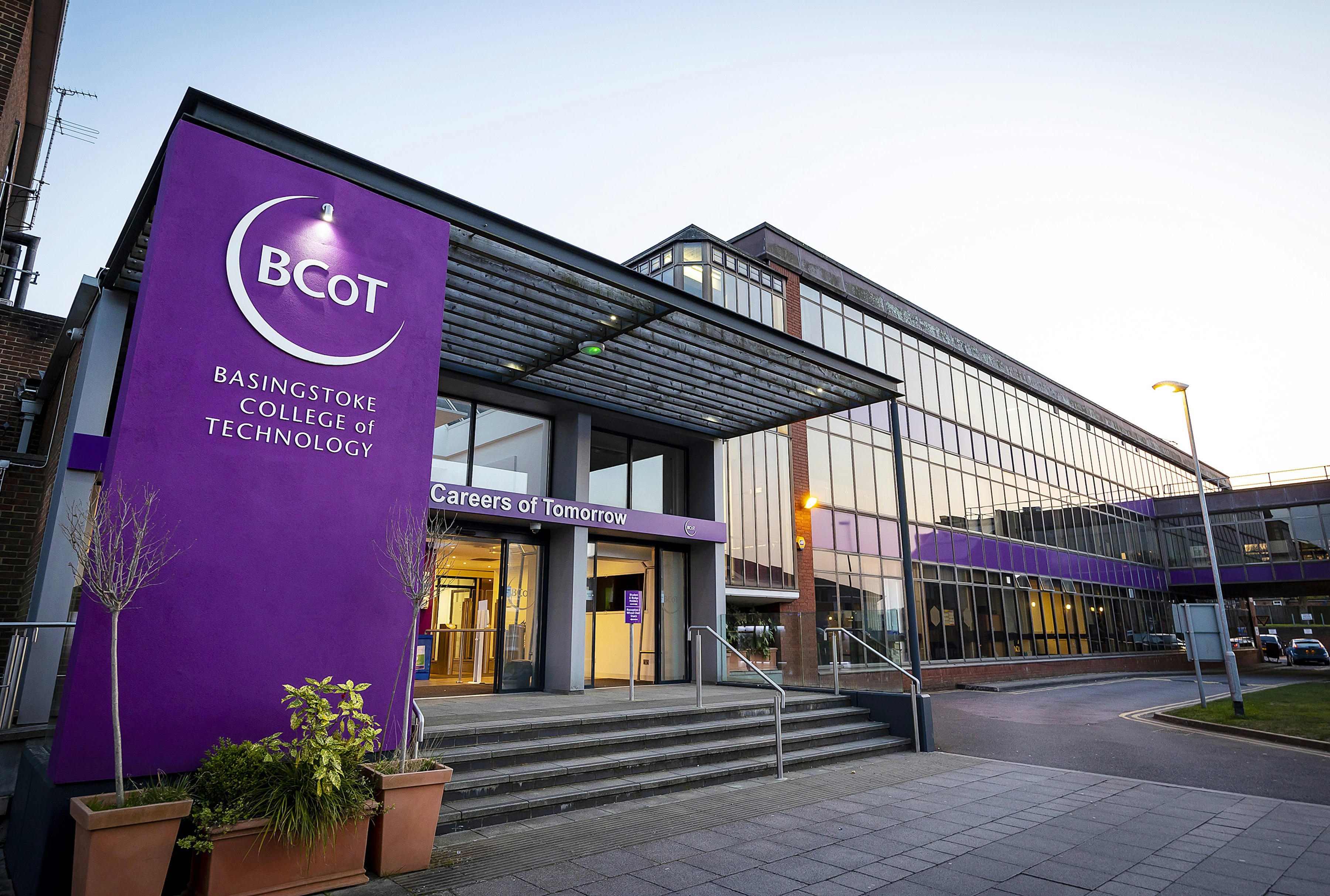 A building is pictured on a sunny day, to the left hand side of the image a purple column reads BCoT Basingstoke College of Technology in white text.