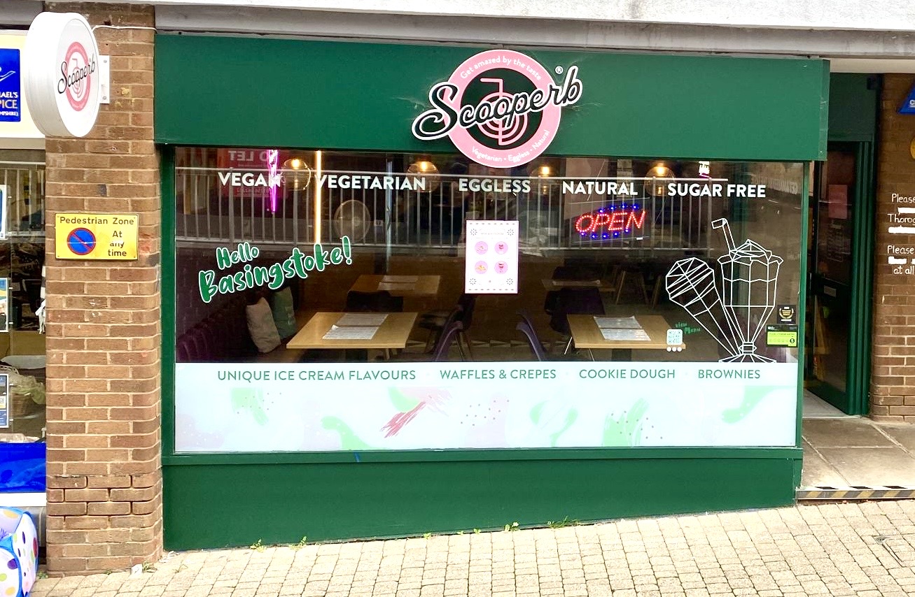 The outside of the shop. A green outside with logo.