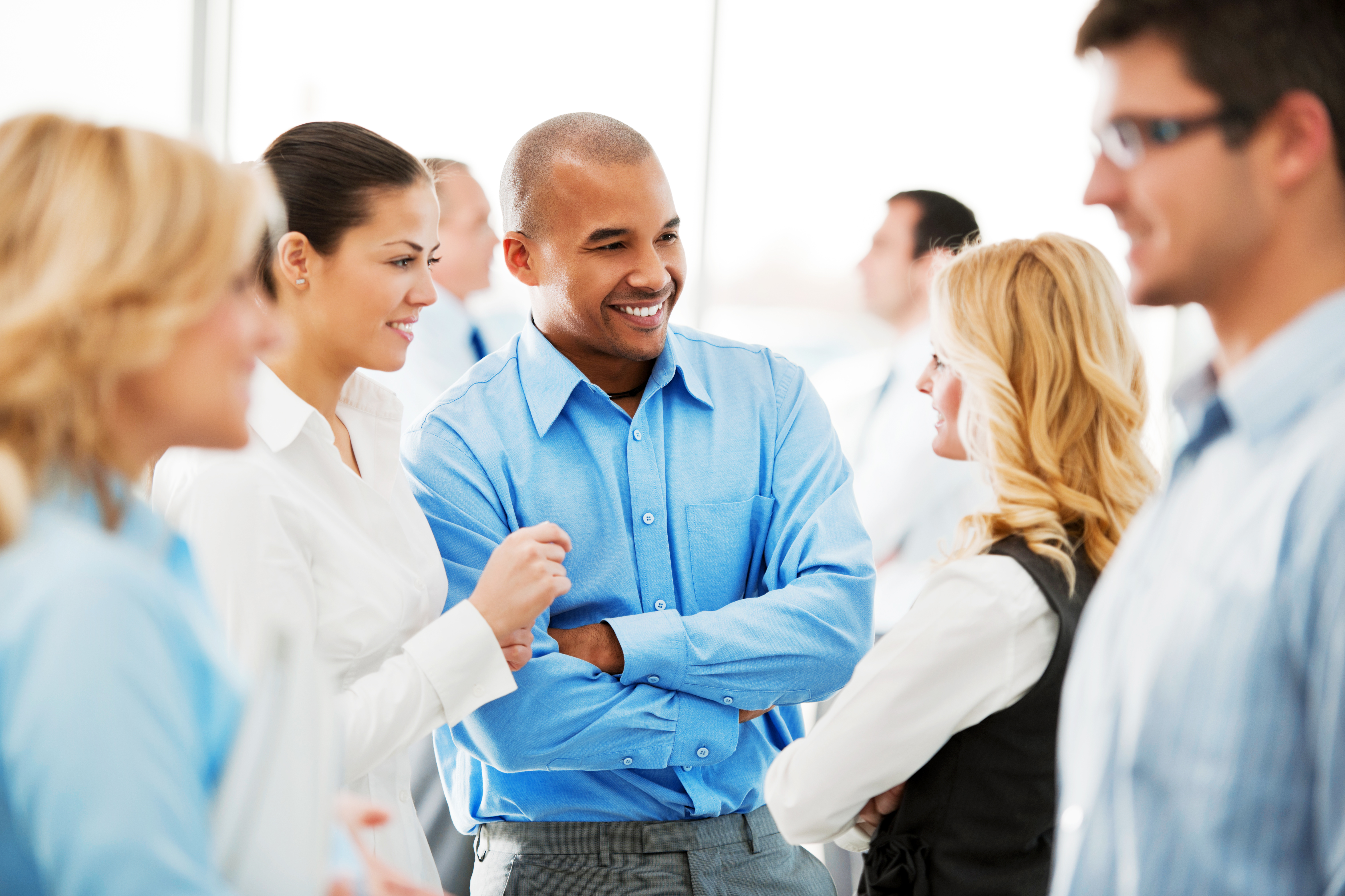 a group of people stand around chatting.