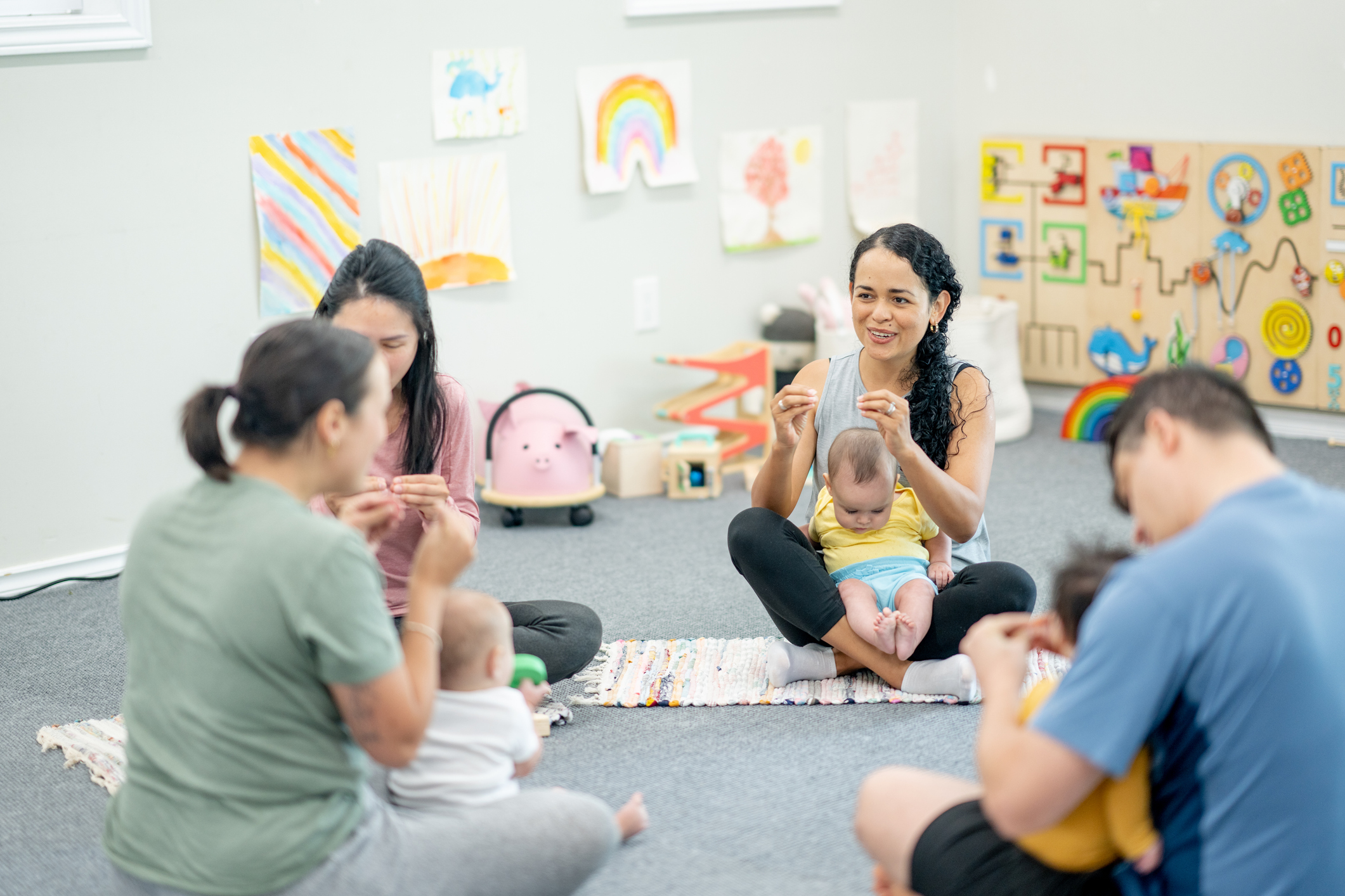 A group of parents sitting around with their babies learning to sign.