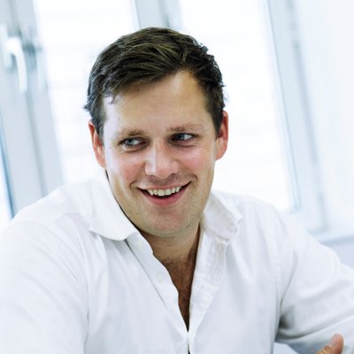 A male wears a white shirt against a white background
