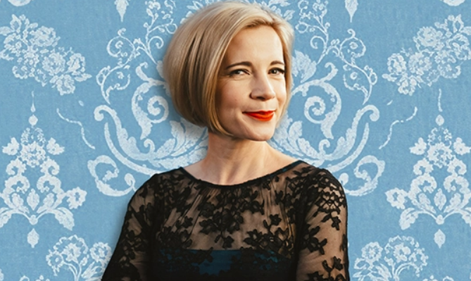 An image of a female wearing black and looking to the side. Behind her is a blue lacy style background.