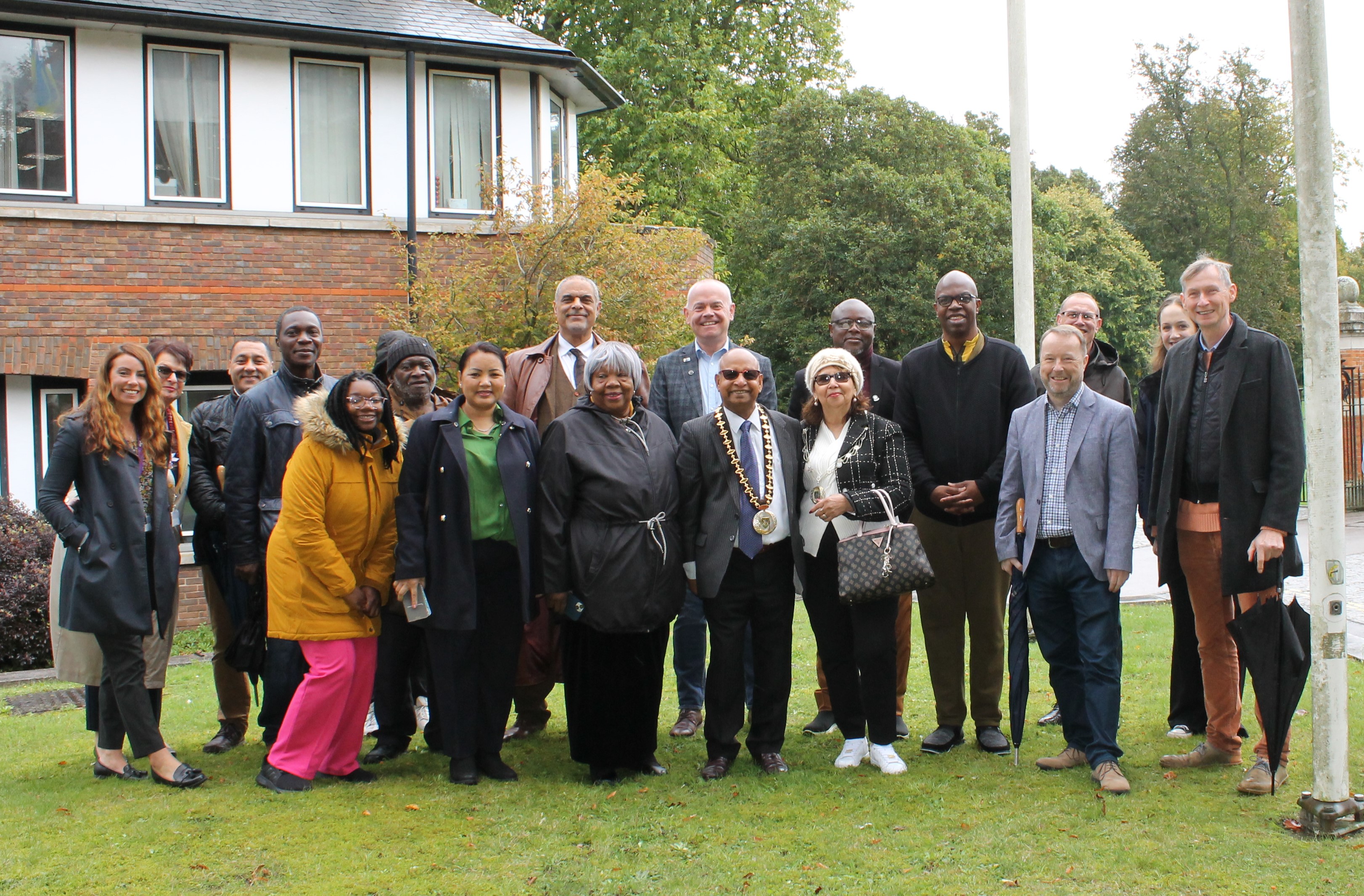 A group of people gather around a flag pole at Basingstoke and Deane Borough Council.