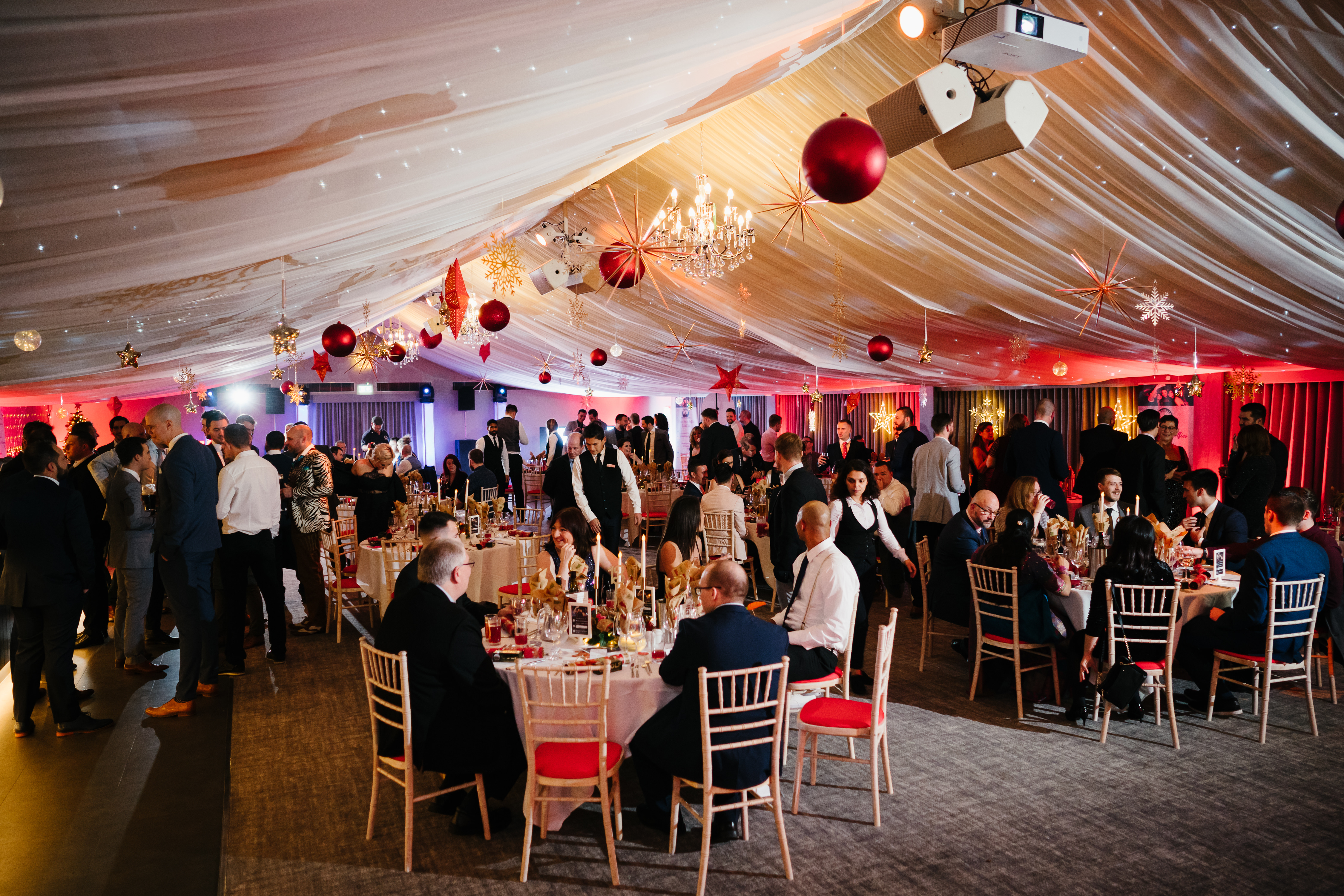 A photograph of the internal marquee at Oakley Hall Hotel - Lots of smartly dressed guests enjoy a shared and Exclusive party nights