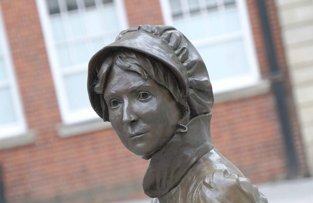 A bronze statue of Jane Austen. In this image you can just see her shoulders and head.